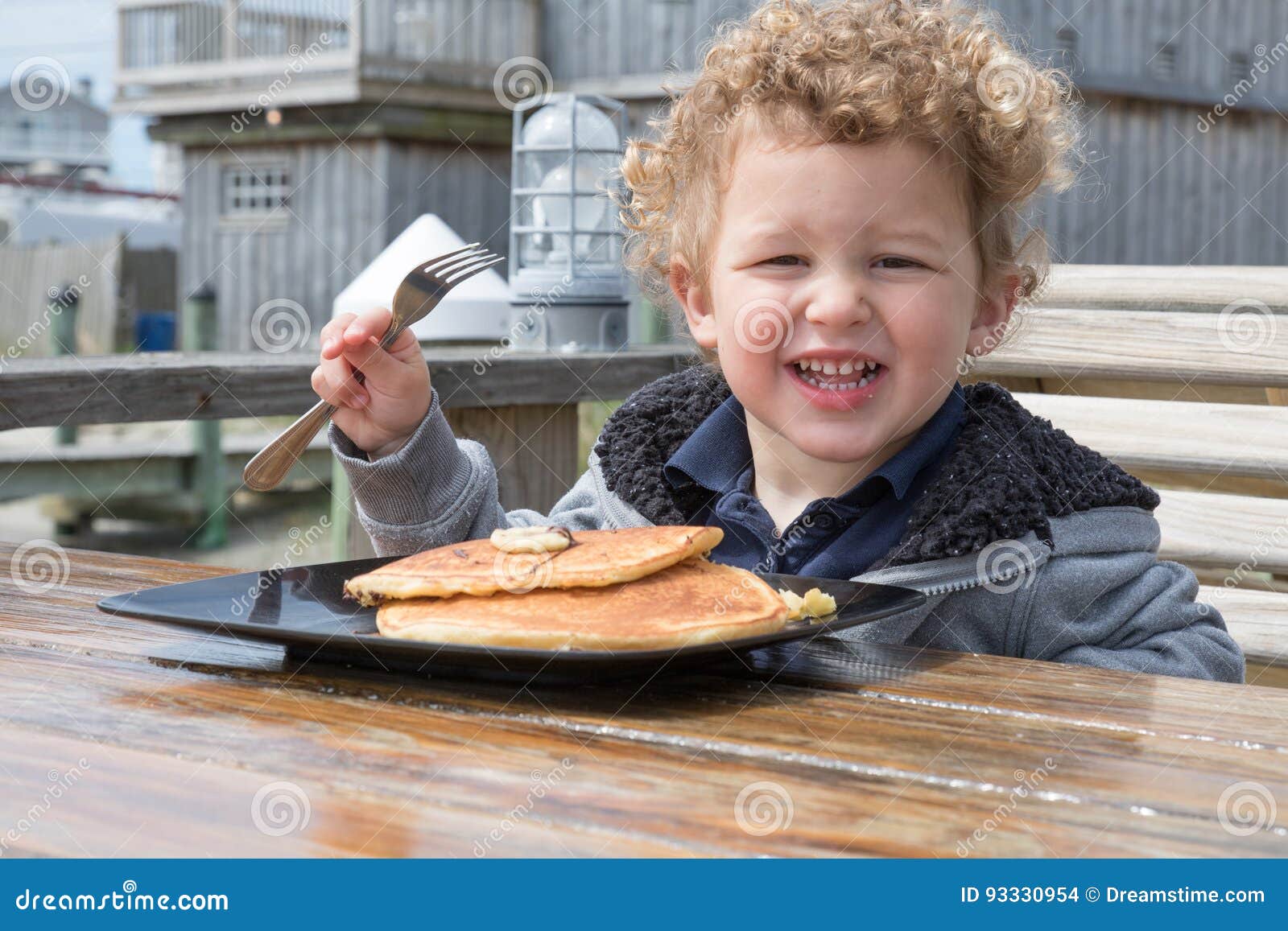 A Little Happy Boy Is Eating Pancakes Outside Stock Photo Image Of