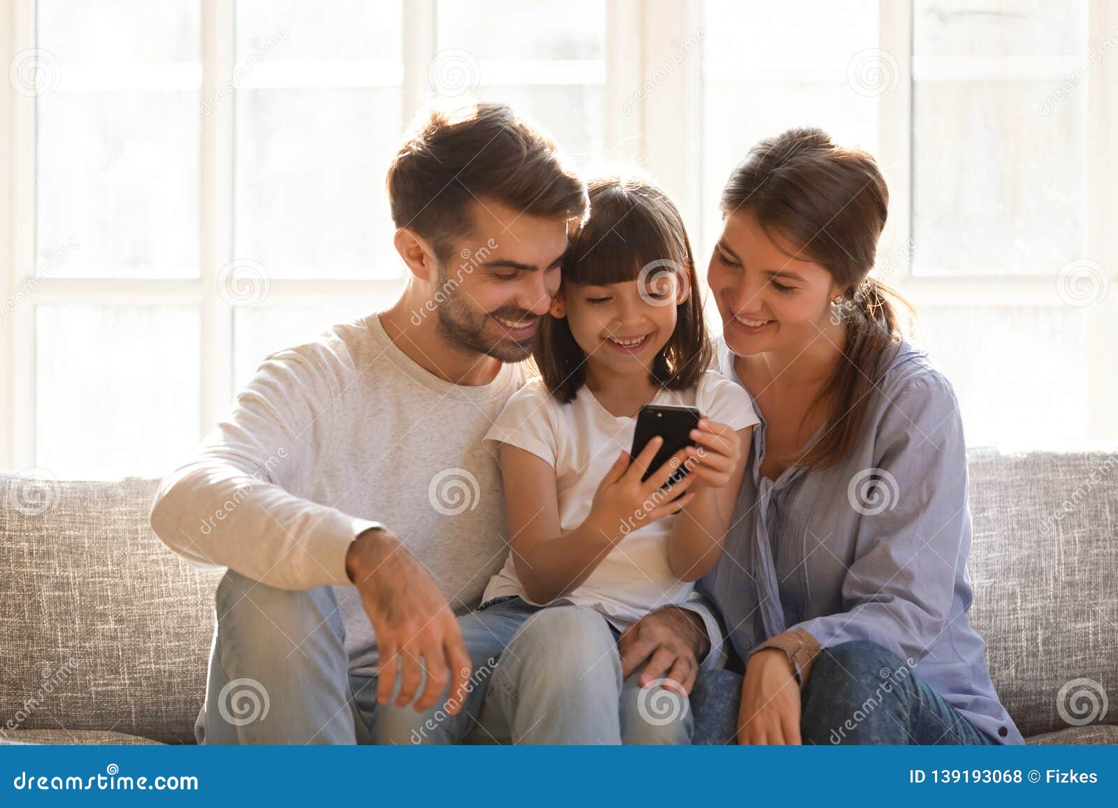 little kid daughter holding cellphone enjoy using mobile app