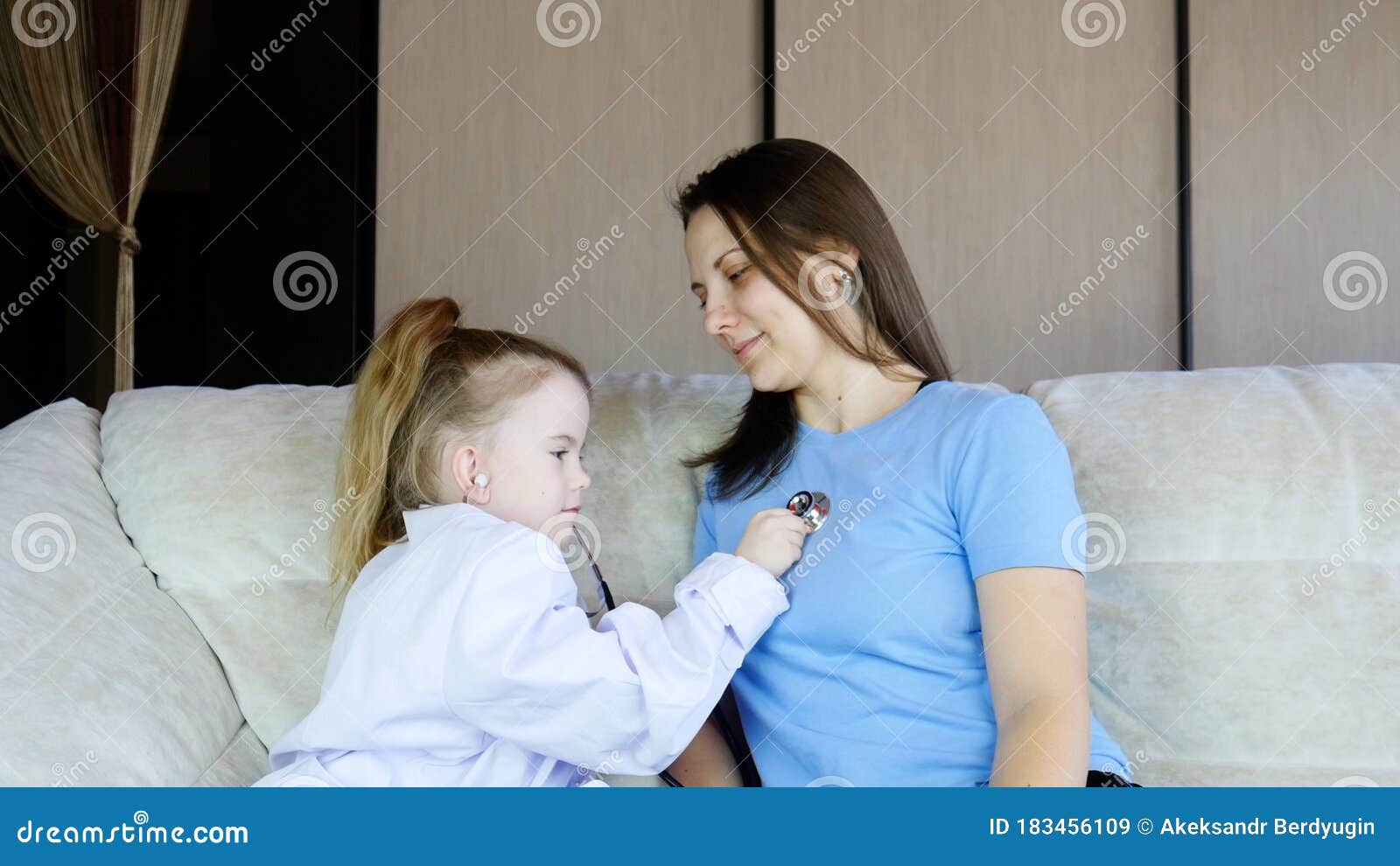 Little Kid Girl Dressed In Medical Uniform Playing As Doctor With Mom