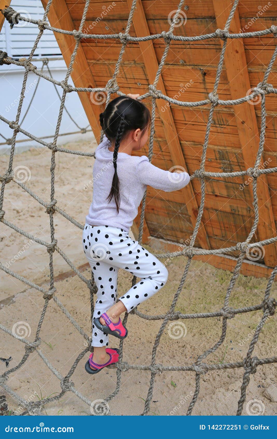 Little Kid Girl at Playground Playing on Climbing Rope Net Stock