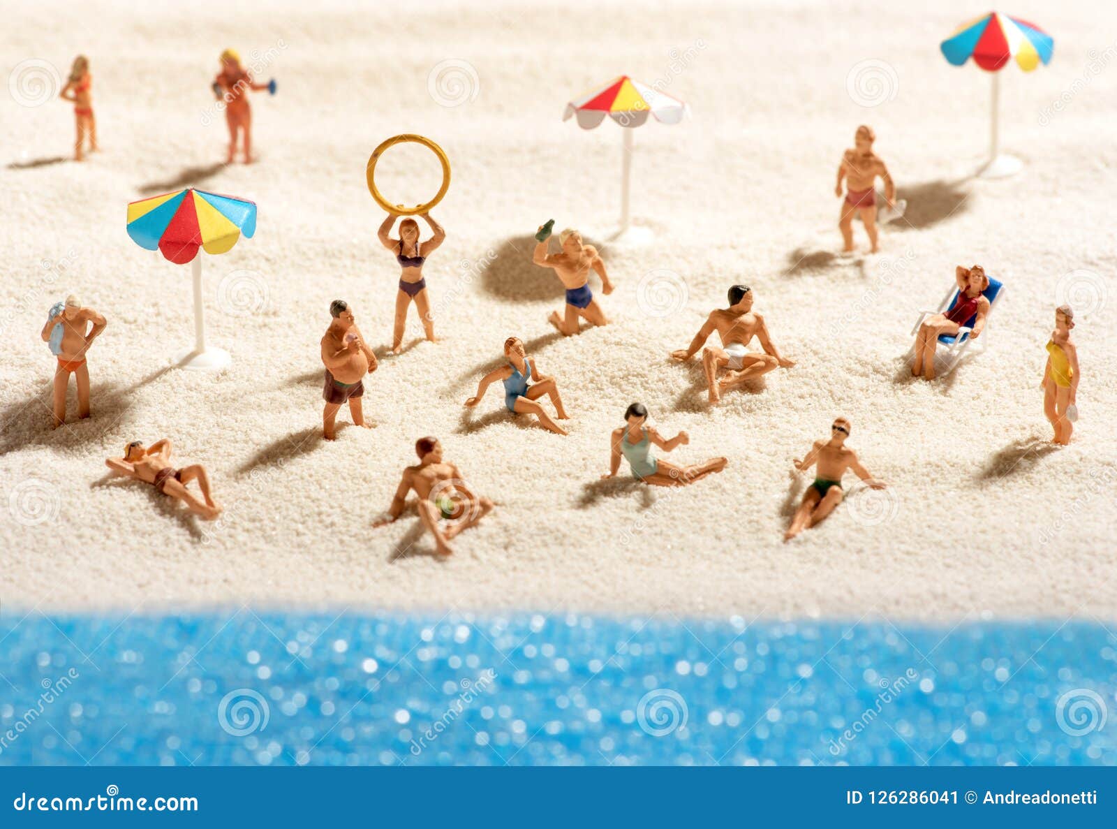 little miniature people sunbathing on a beach