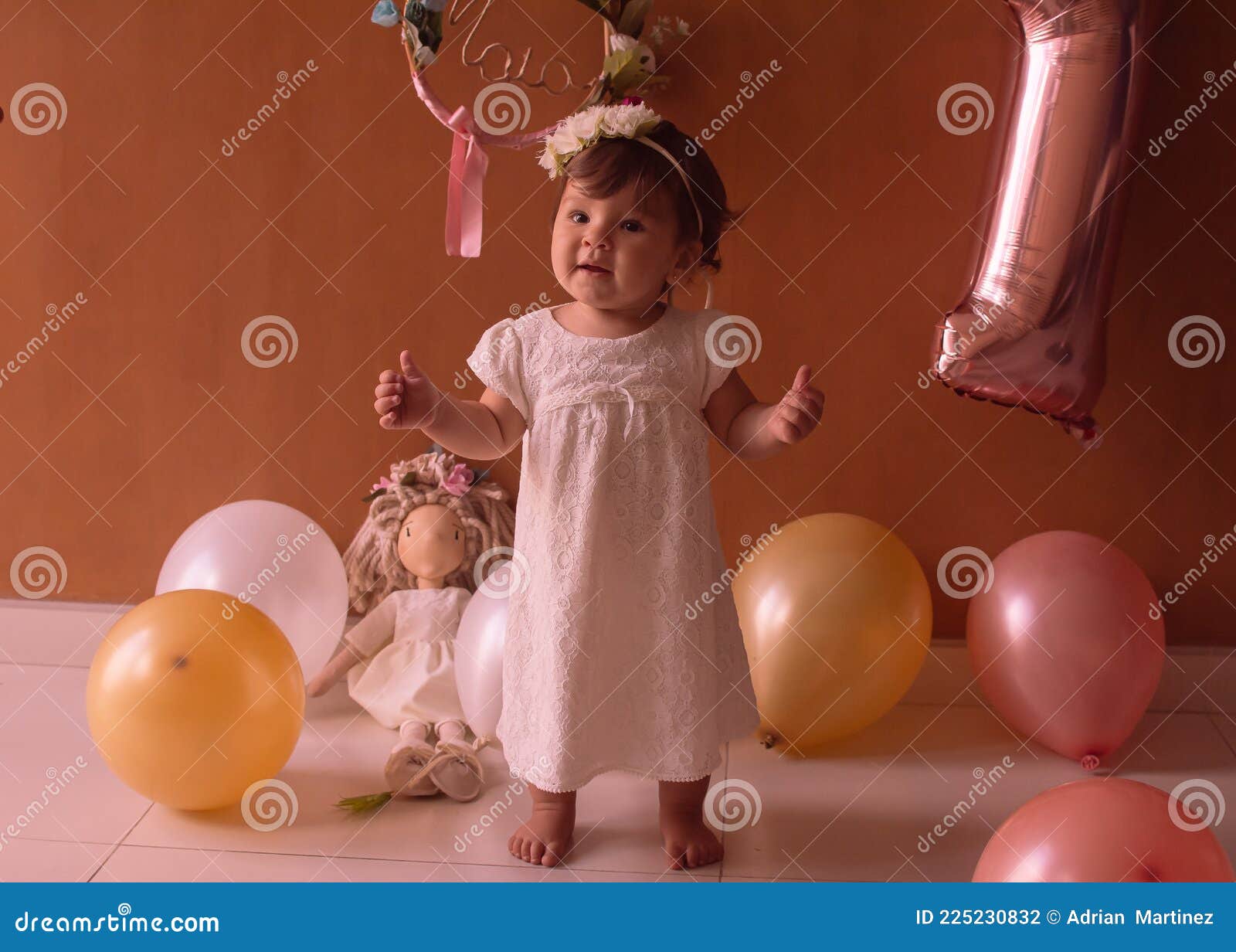 little one year girl baby with balones and dolly