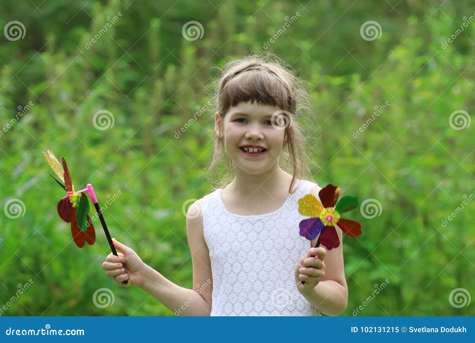 Little Pretty Girl With Two Windmills Toys In Summer Stock Image