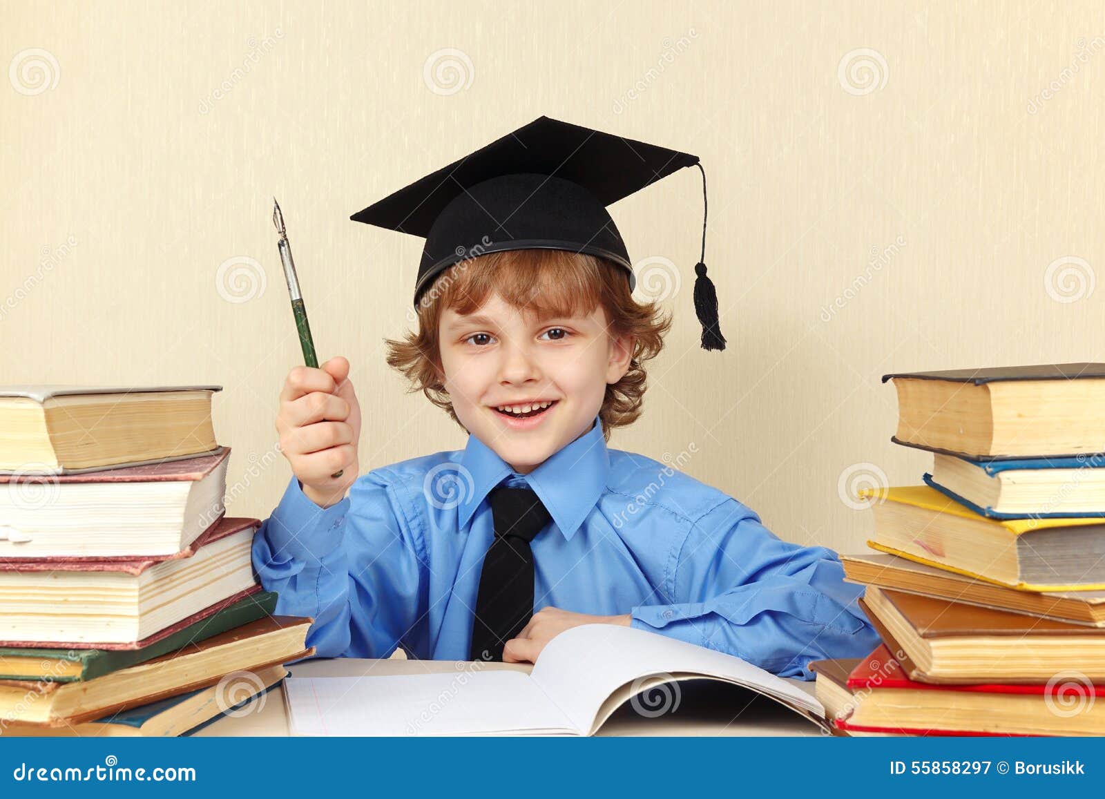 little smiling boy in academic hat with rarity pen among old books