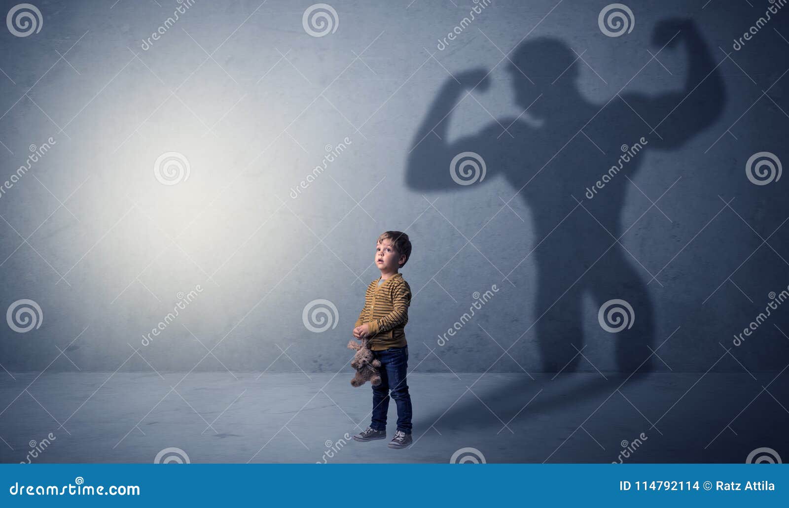 muscleman shadow behind waggish little boy