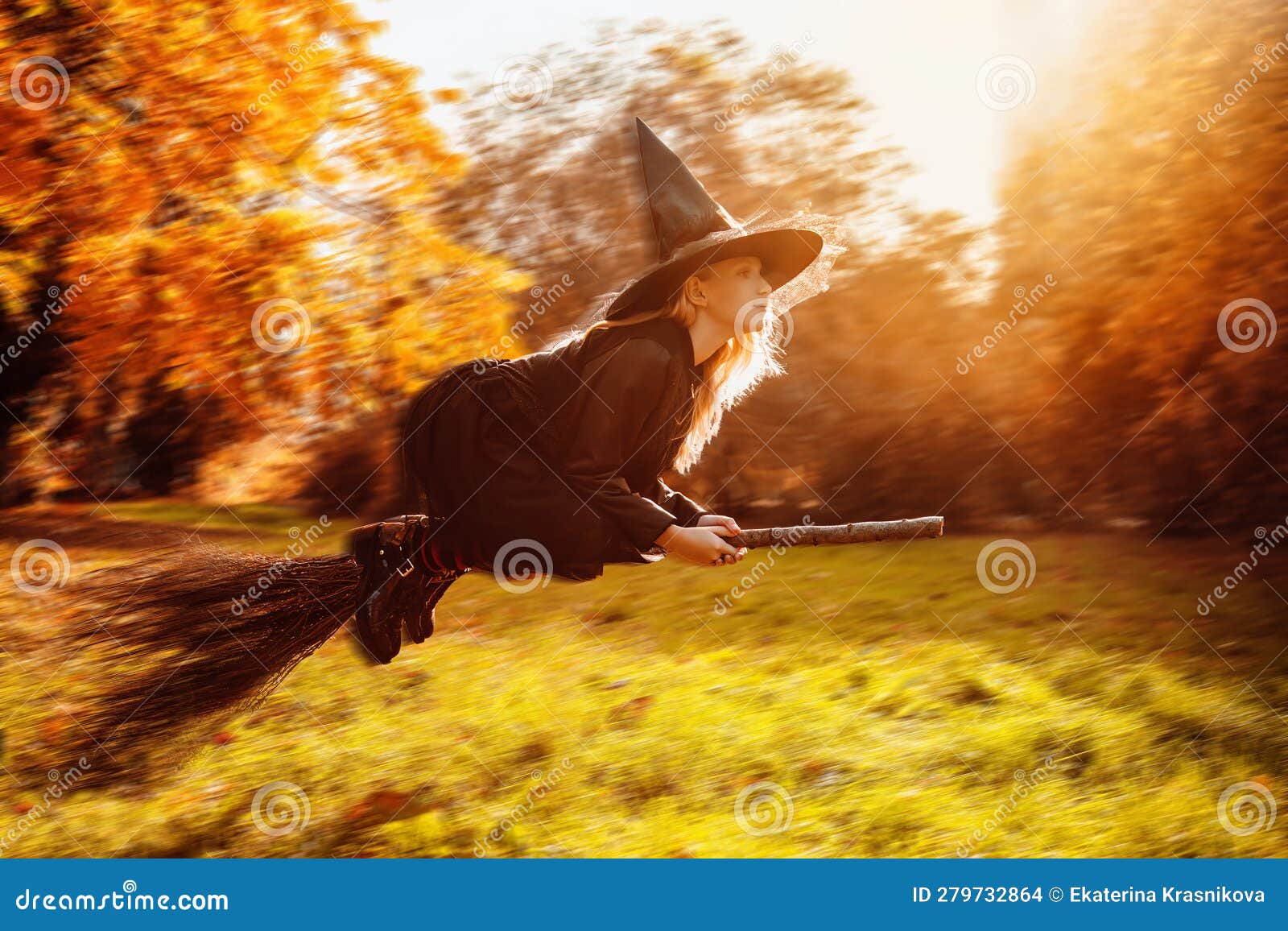 The Little Witch is Flying on a Broomstick in the Autumn Forest at