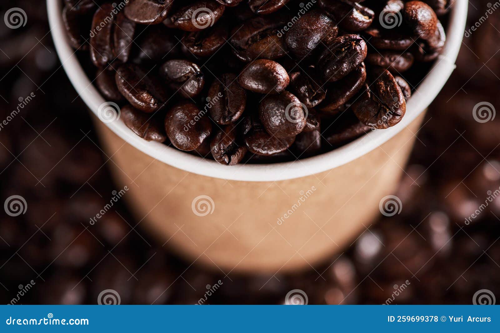 livin la vida mocha. closeup shot of a paper cup filled with coffee beans.