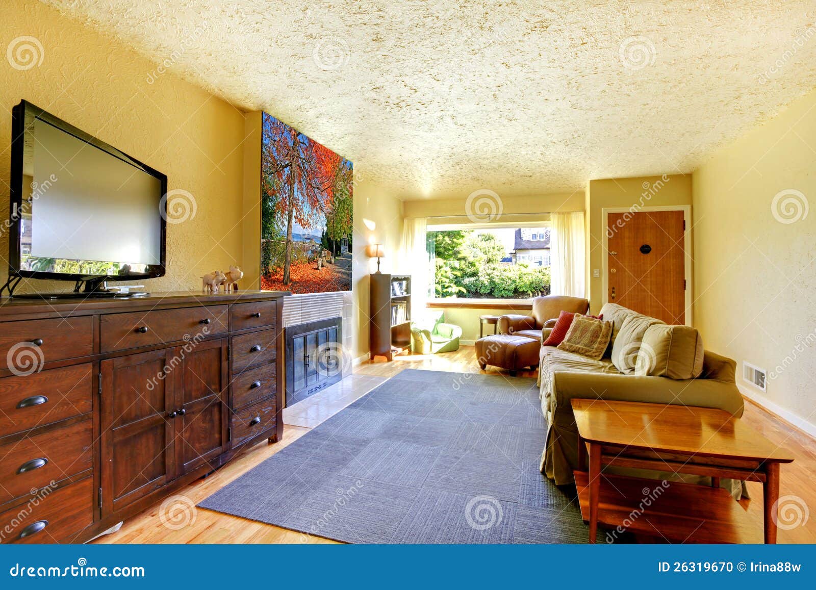 Living Room With Grey Rug Yellow Walls And TV On Large Dresser