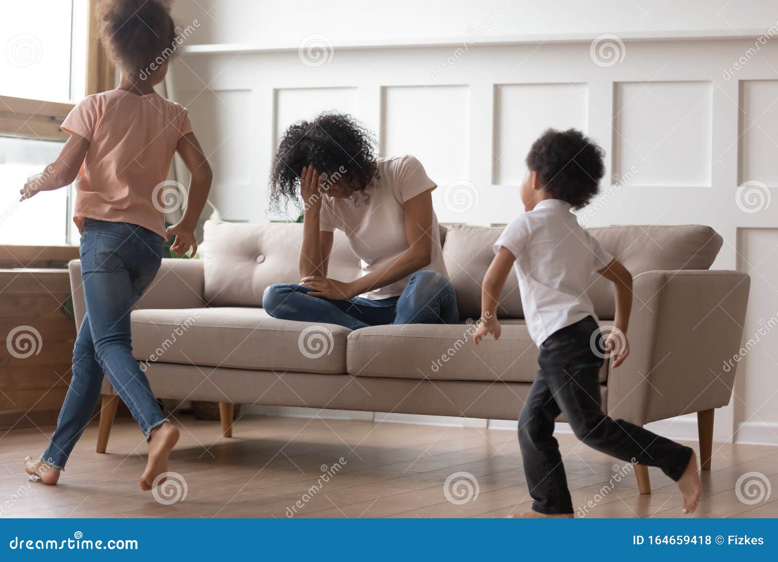 African Mother Sit On Couch Can`t Handle With Noisy Kids
