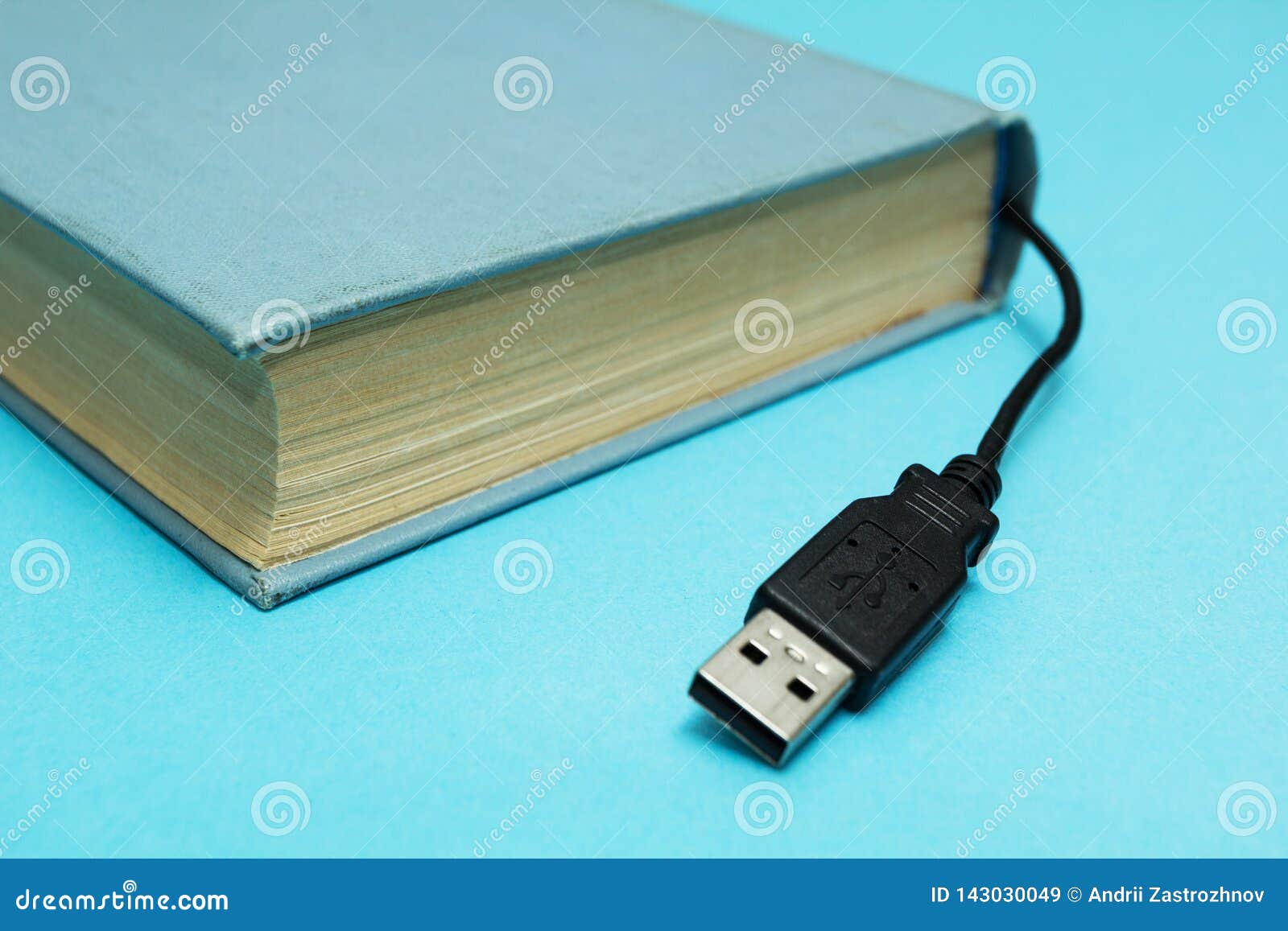 Livro com um conector para a conexão a um computador em um fundo azul