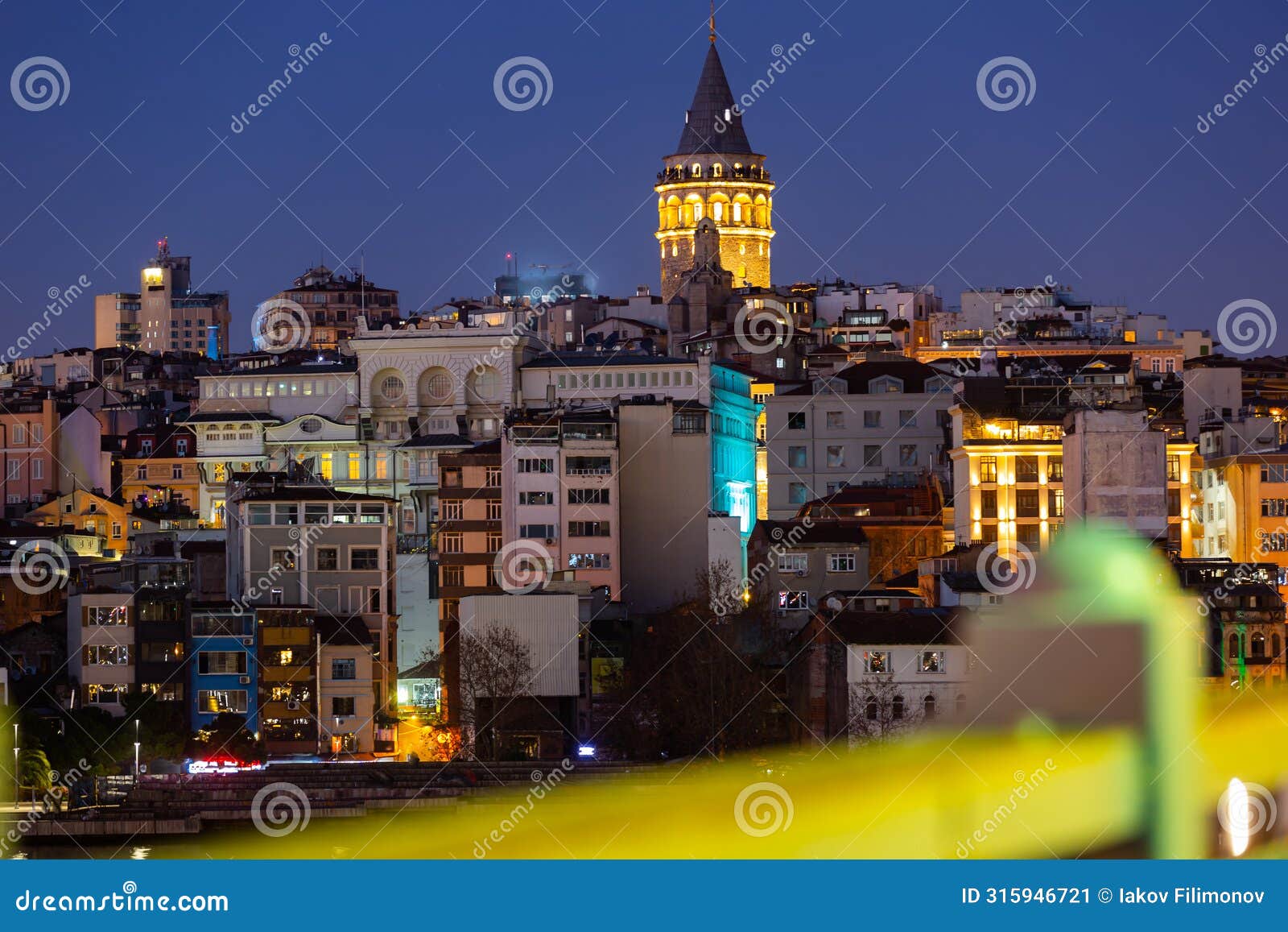 llighted galata tower topping over beyoglu residential buildings, istanbul