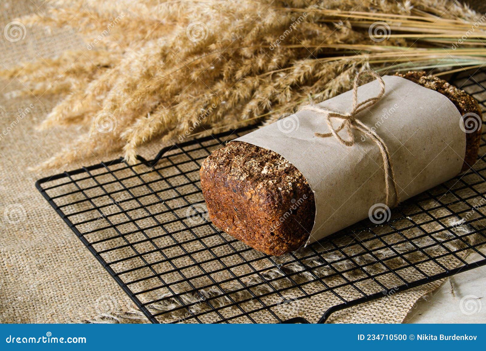 a loaf of sourdough rye bread wrapped in craft paper.