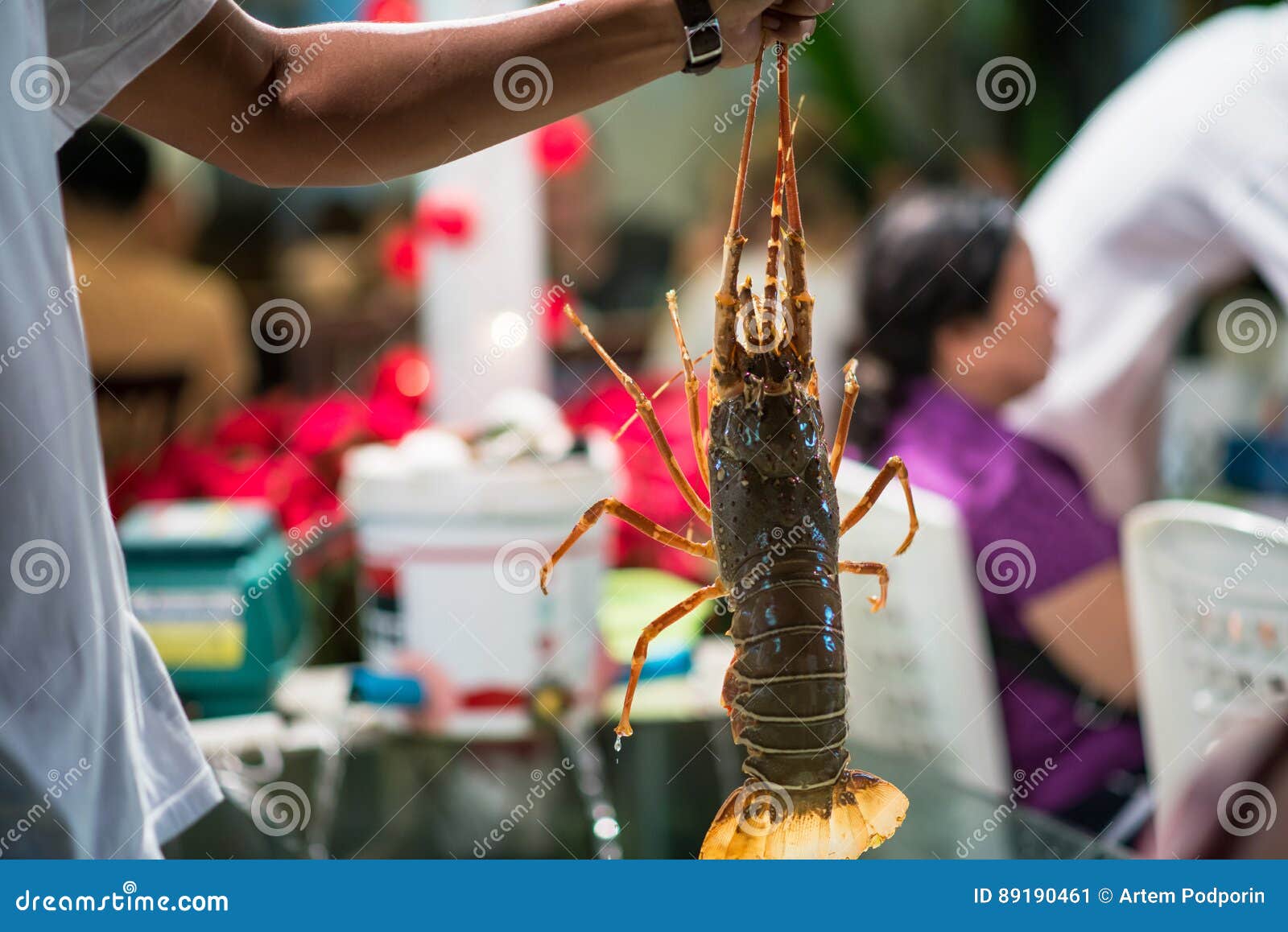 Lobster. A Hand Holding A Giant Lobster At A Seafood Buffet. Soft Focus