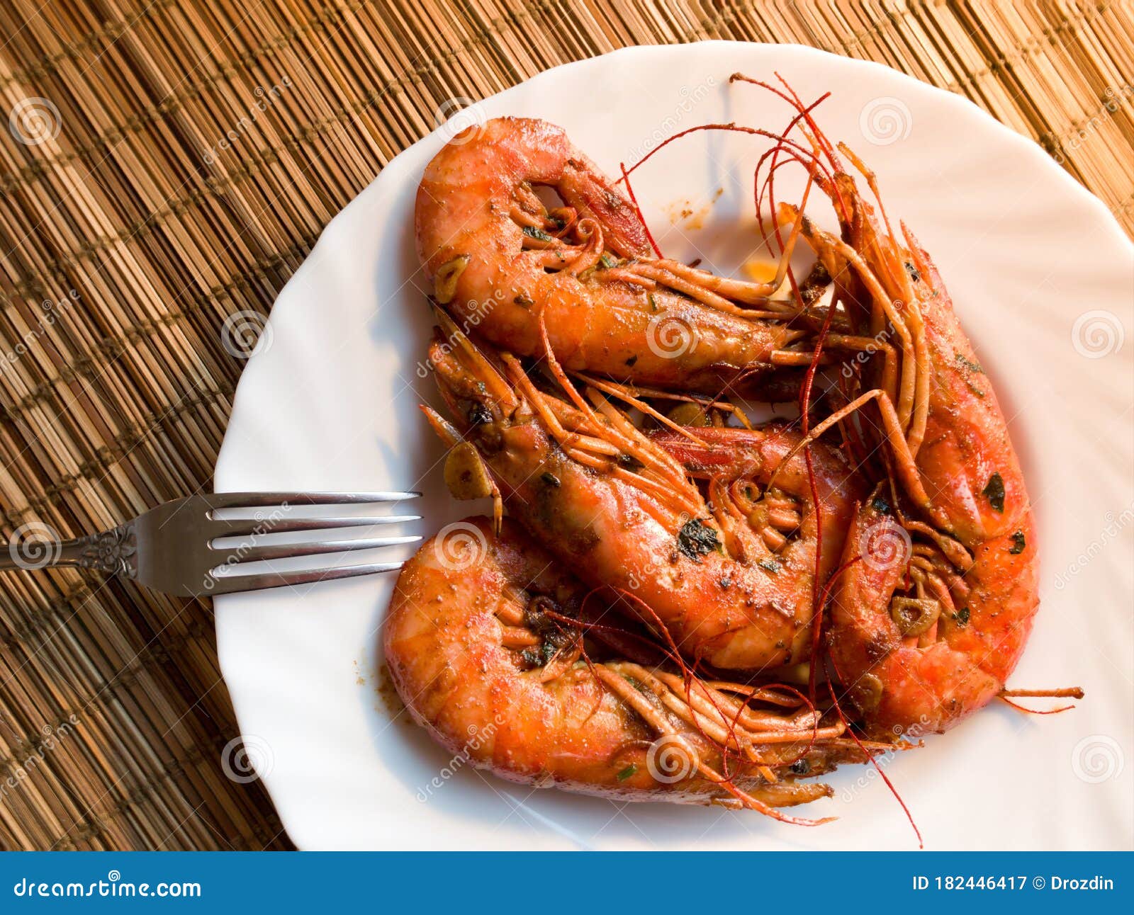 A Fried Lobster on a White Plate, a Straw Lining Under Plate, Fork