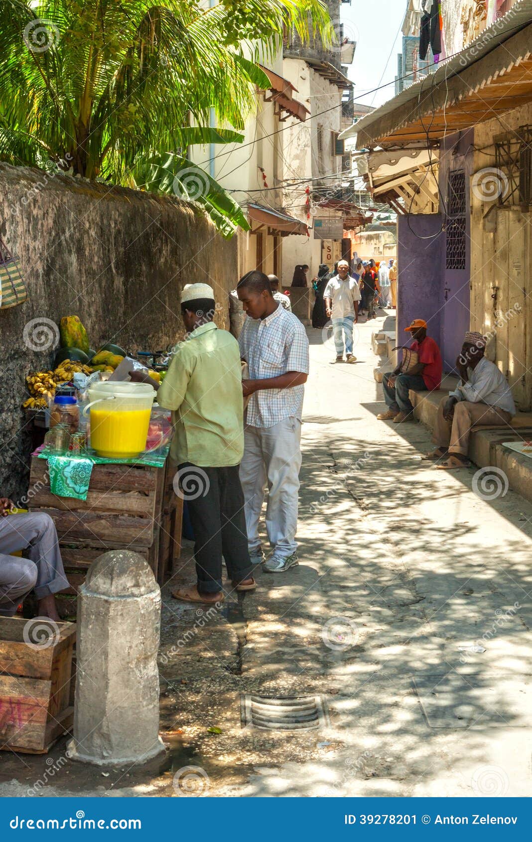 STONE TOWN, ZANZIBAR/TANZANIA - APRIL 4 2012: Local people on the streets in heart of city, which mostly consists of a maze of narrow alleys lined by houses, shops, bazaars and mosques. Most streets are too narrow for cars.