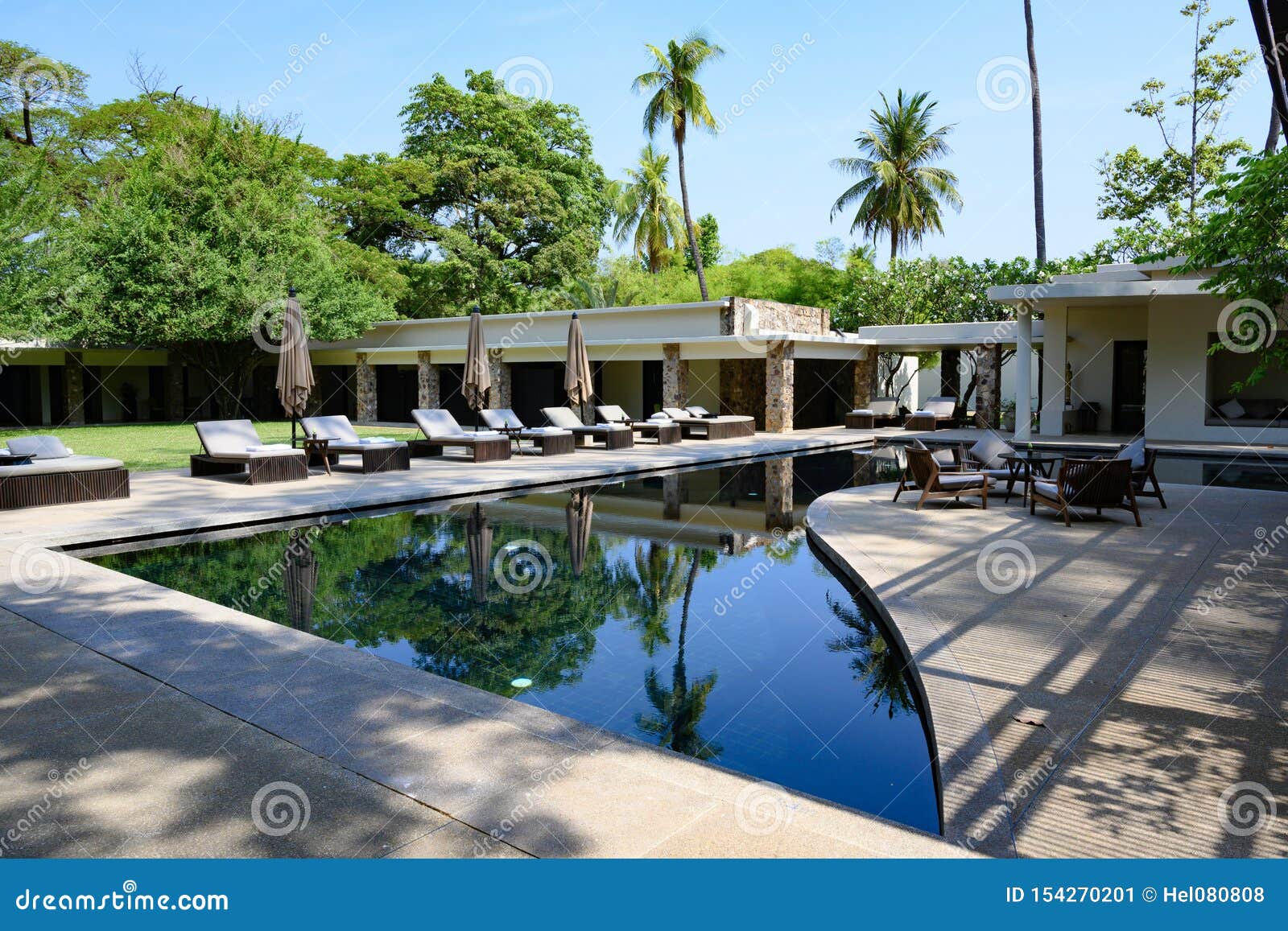 Località di soggiorno Amansara, strada a Angkor, Siem Riep, regno di Cambogia. Bello Aman Resort - un hotel molto piccolo di cinque stelle - uno dello stagno con i lettini La località di soggiorno è individuata 10 minuti dal sito del patrimonio mondiale dell'Unesco del parco archeologico di Angkor