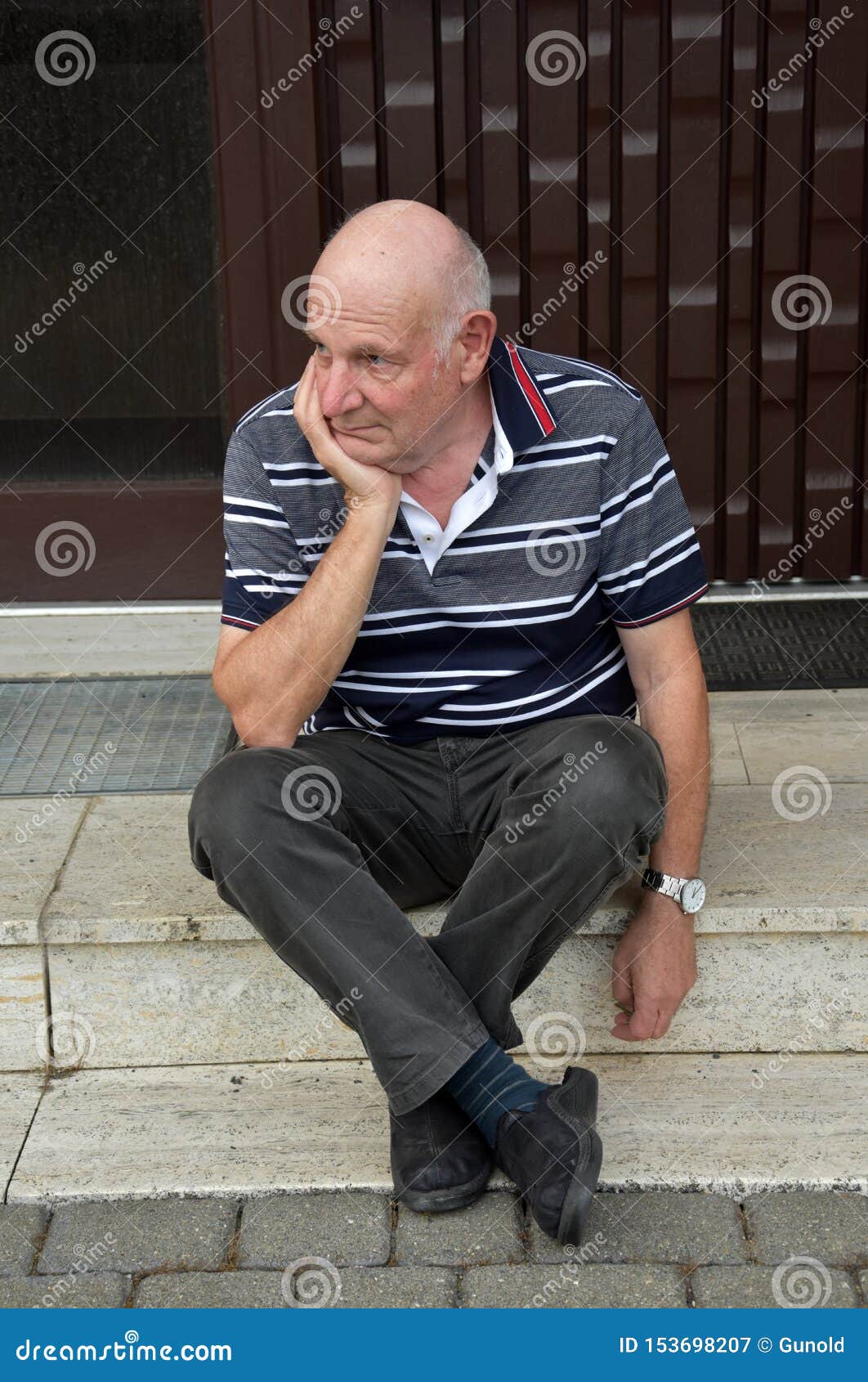 locked out senior man sitting in front of his house