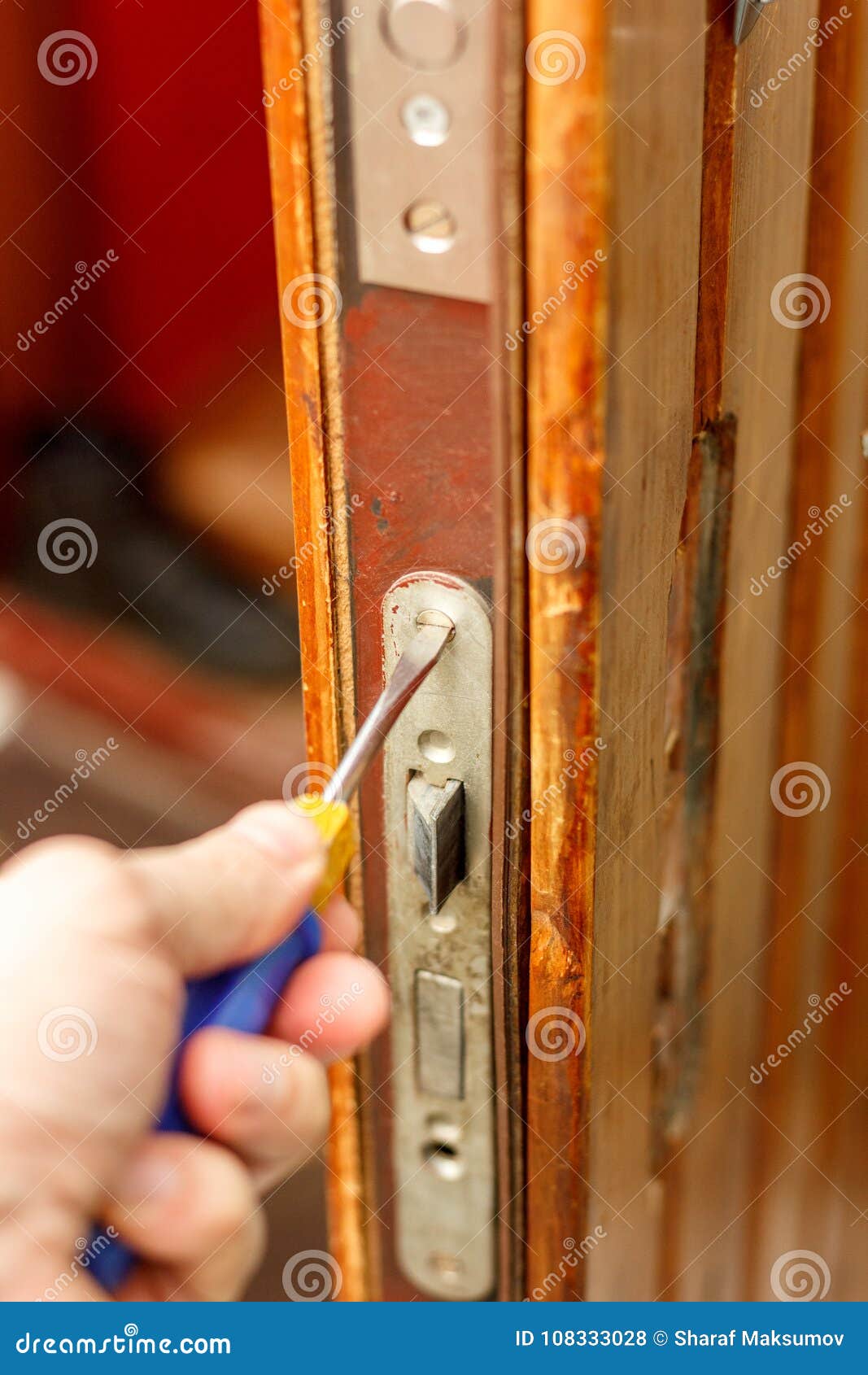 Locksmith Making Installation of Door Lock with Screwdriver. Stock