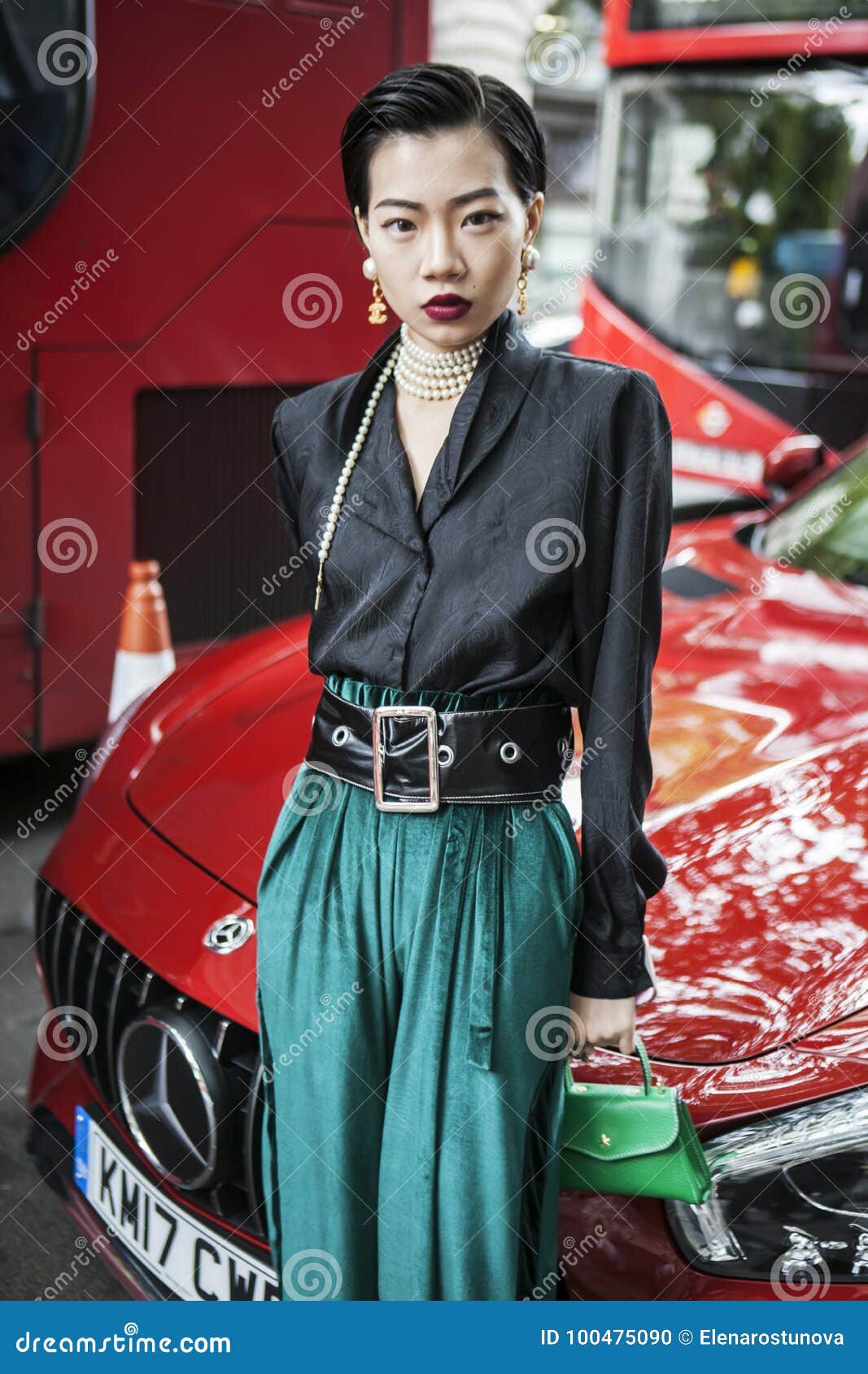 Beautiful and Stylish a Girl in a Black Blouse, a Green Pants, Vintage  Chanel Earrings Posing during the London Fashion Week. Outs Editorial Image  - Image of model, fashion: 100475090
