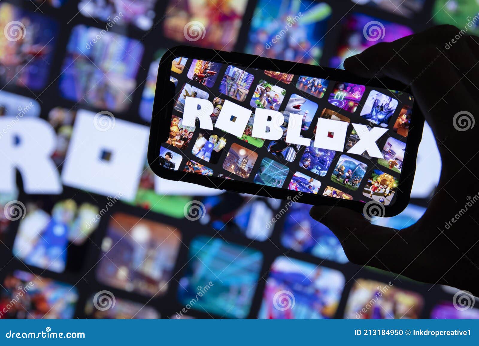 Roblox Logo and App on a Mobile Screen in a Hand Editorial Stock