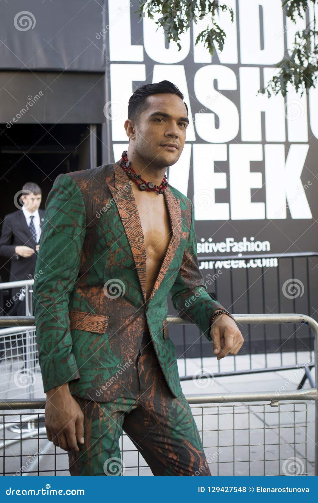 A Man In A Green Suit With Flowers From 