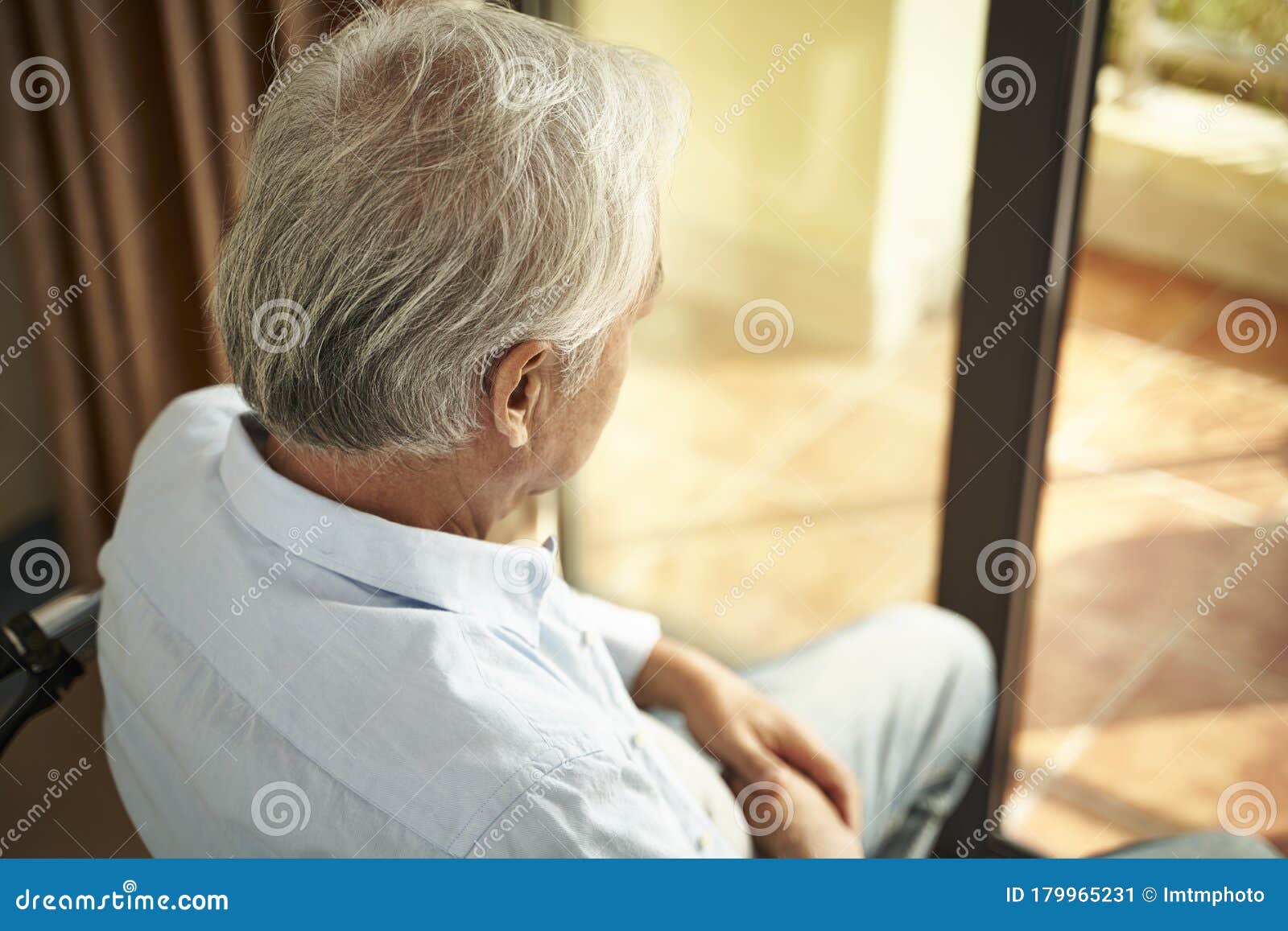 lonely asian elderly man sitting in wheel chair in nursing home