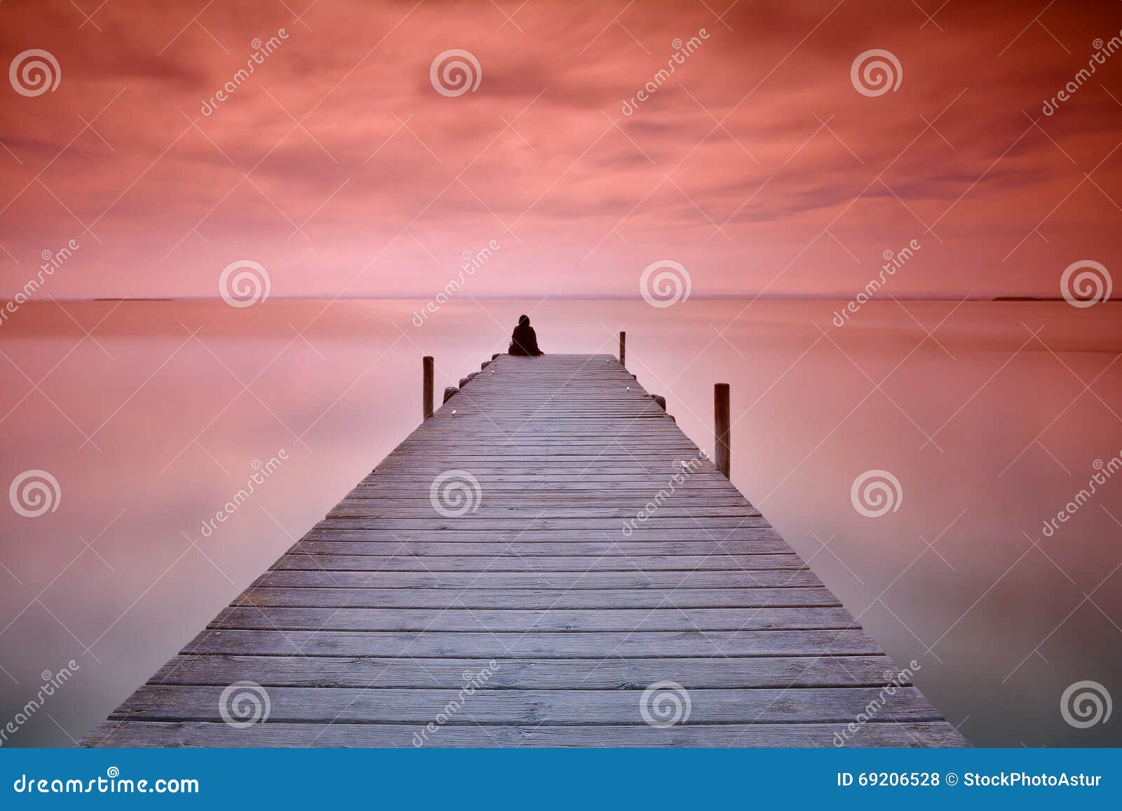lonely person sitting on pier