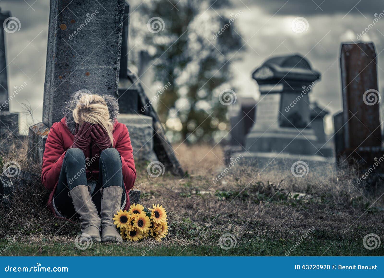 lonely sad young woman in mourning in front of a gravestone