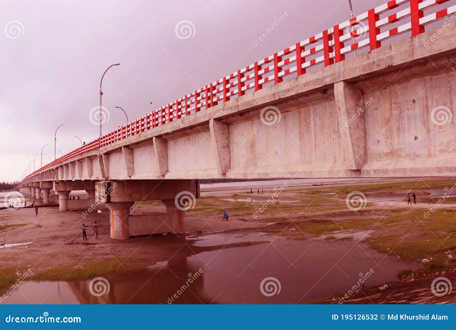 long big concrete bridge.an elevated concrete highway spanning across a dark cloudy sky.view under the grey briage in the city.