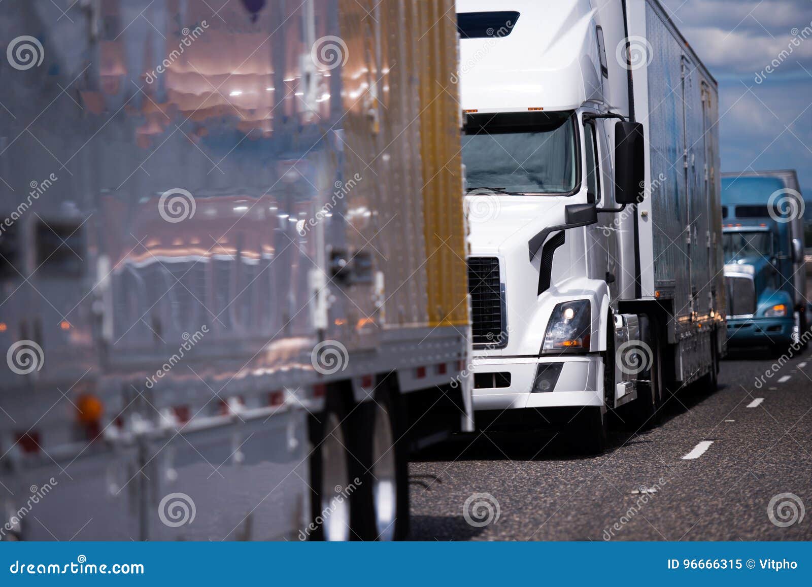 long big rigs semi trucks and trailer convoy on the road