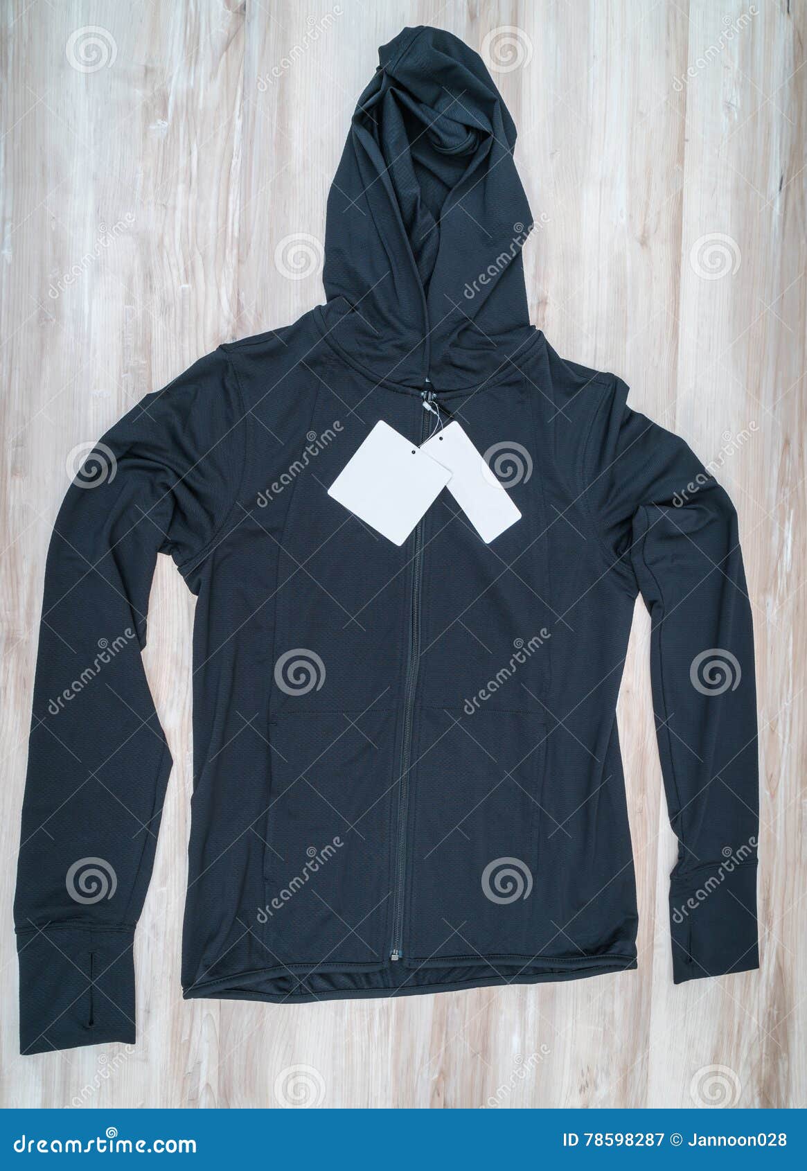 Long Black Jacket with Price Tag on Wooden Background . Stock