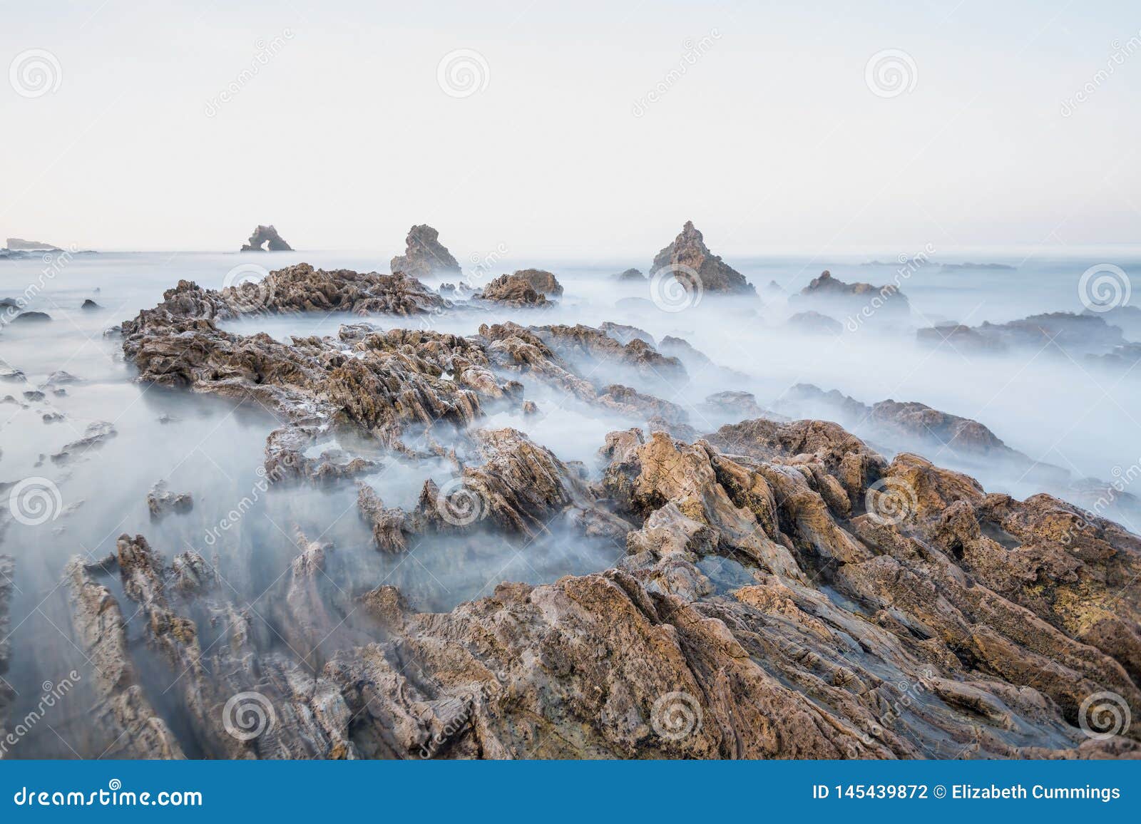 Long Exposure Fluffy Ocean Mists Rush Over Tidal Pool Rocks at the