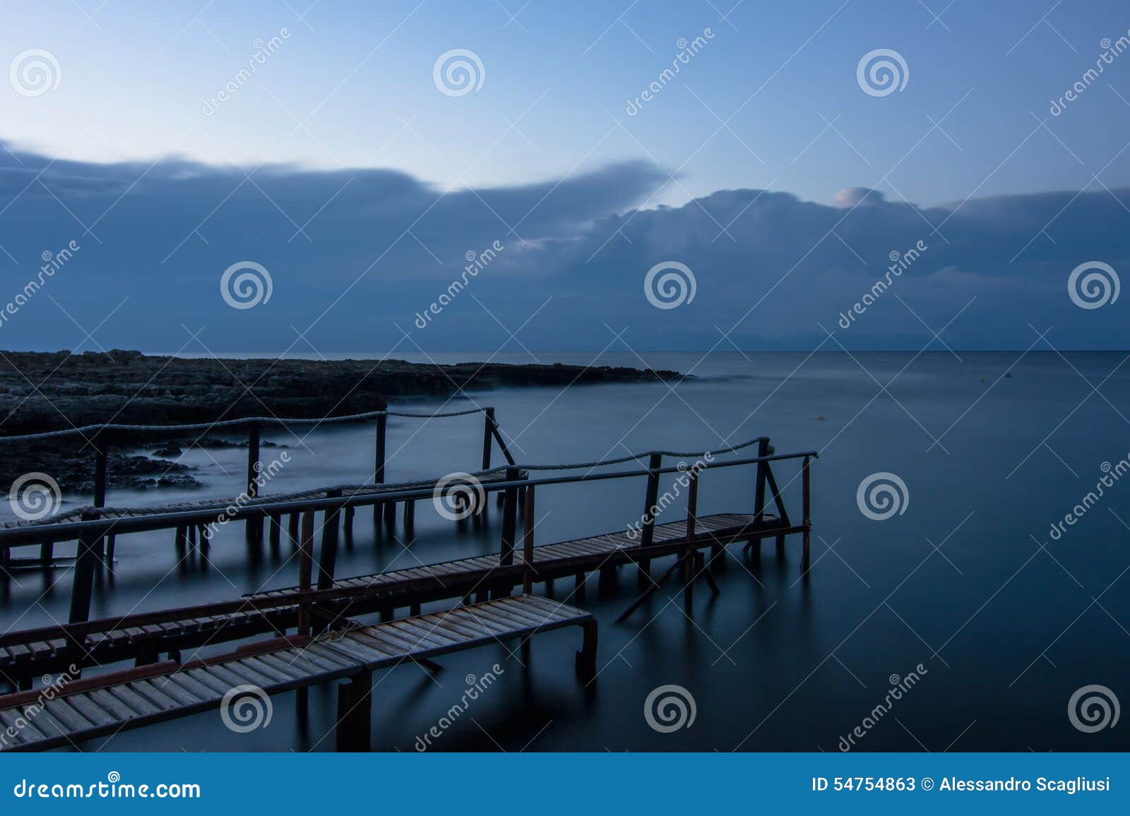 long exposure: a wooden pier after sunset in a blu autumn sky