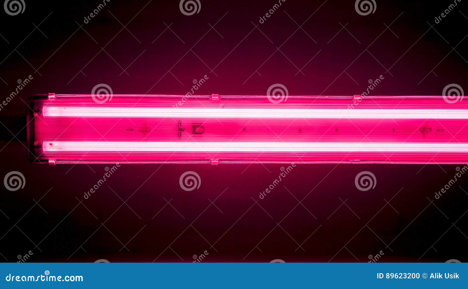 long lamp divided into sections with lights and gradient effect against dark office ceiling