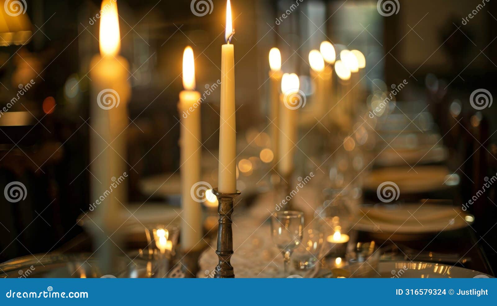 a long narrow dining table is lined with a row of elegant taper candles as the centerpiece creating a dramatic and