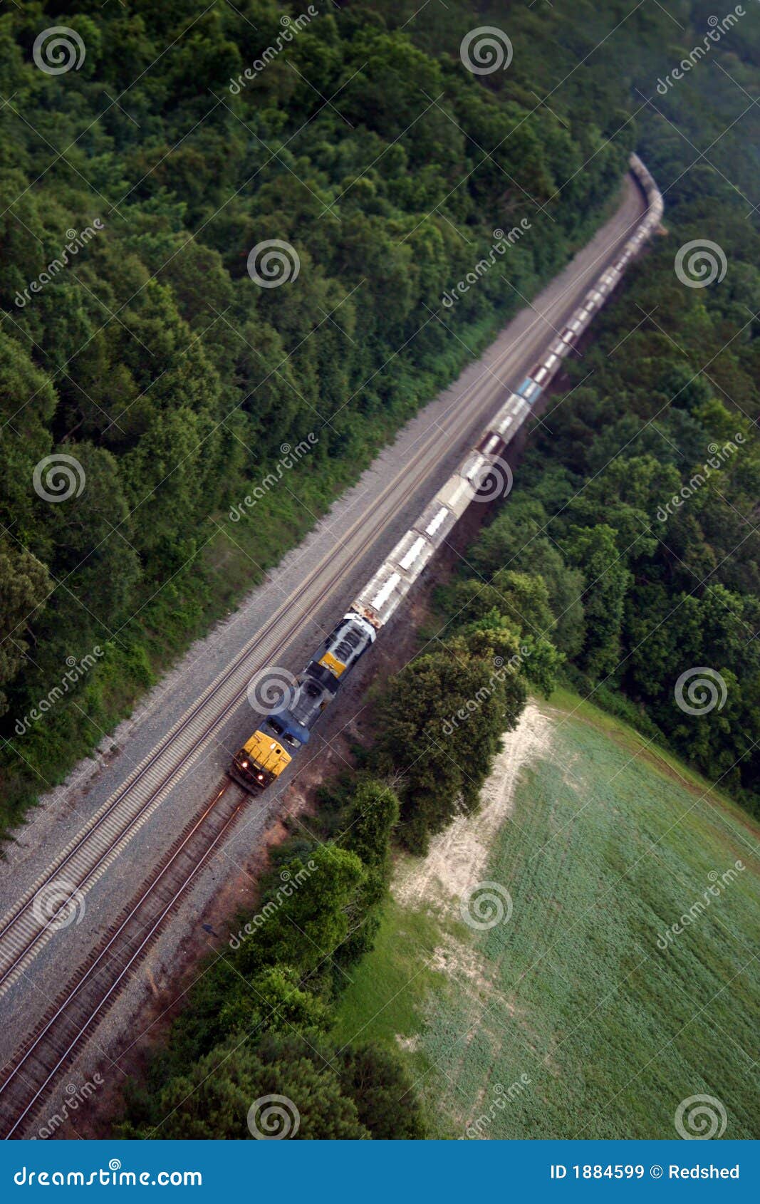 Long Train. Long blue and yellow train coming around curve from the air