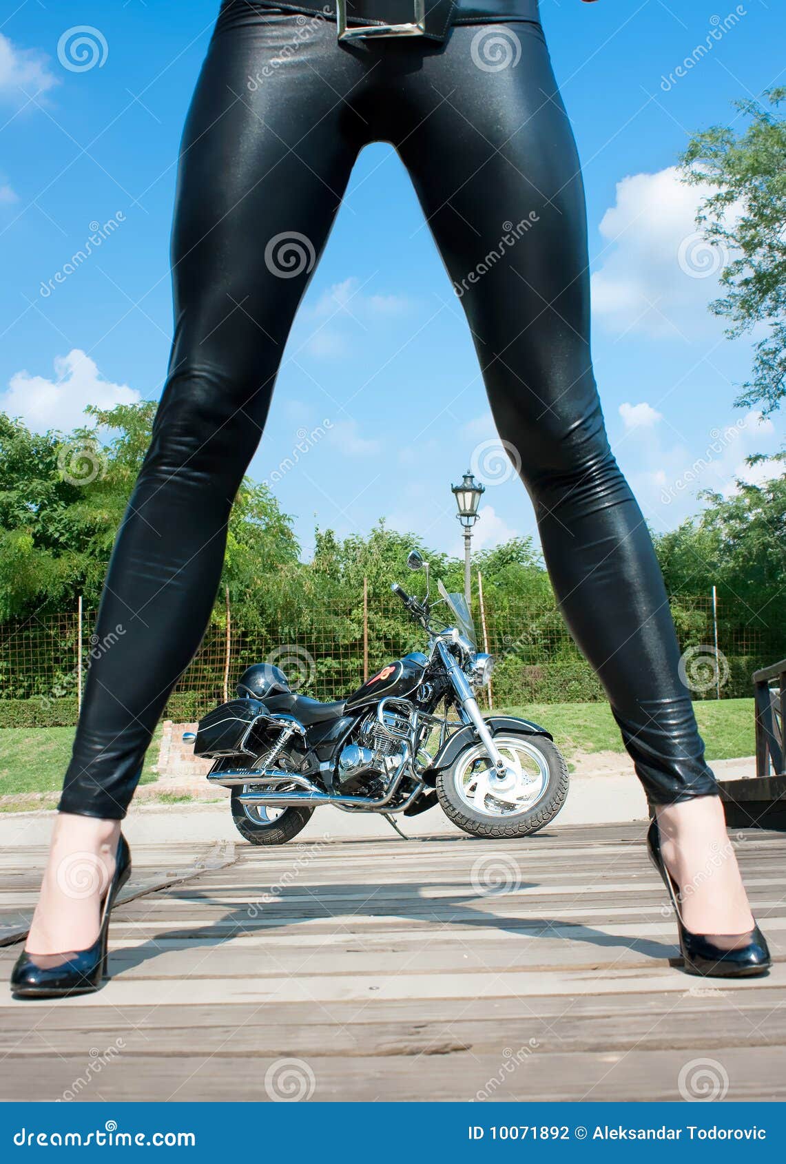 long woman`s legs with view on motorbike