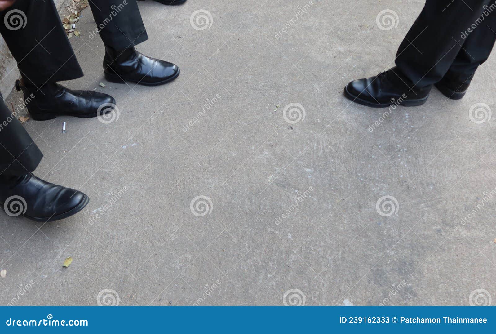 look above the legs of a man wearing black slacks wearing leather shoes.