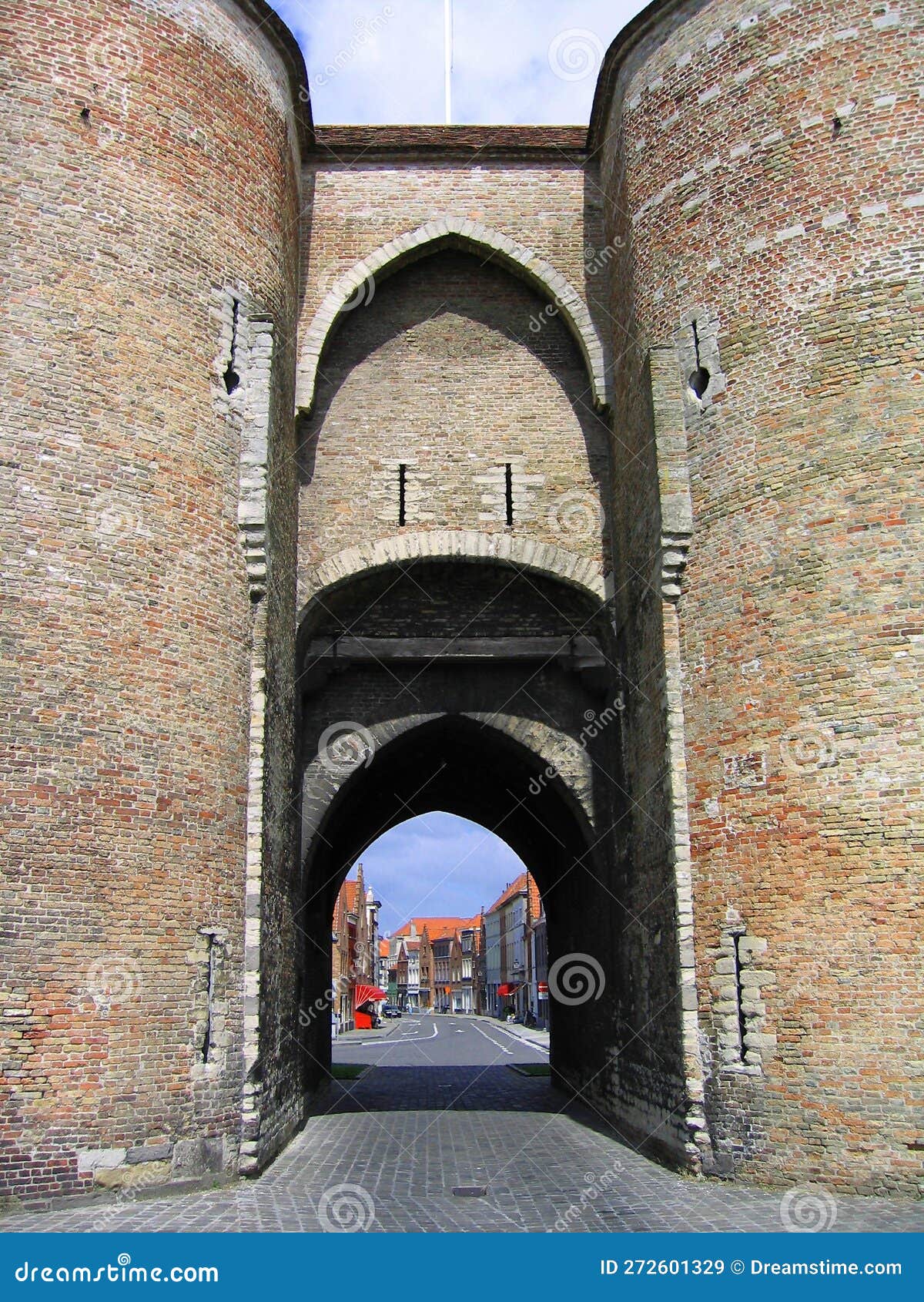 looking through the gentpoort, gate of ghent, part of the medieval city fortifications of bruges, belgium