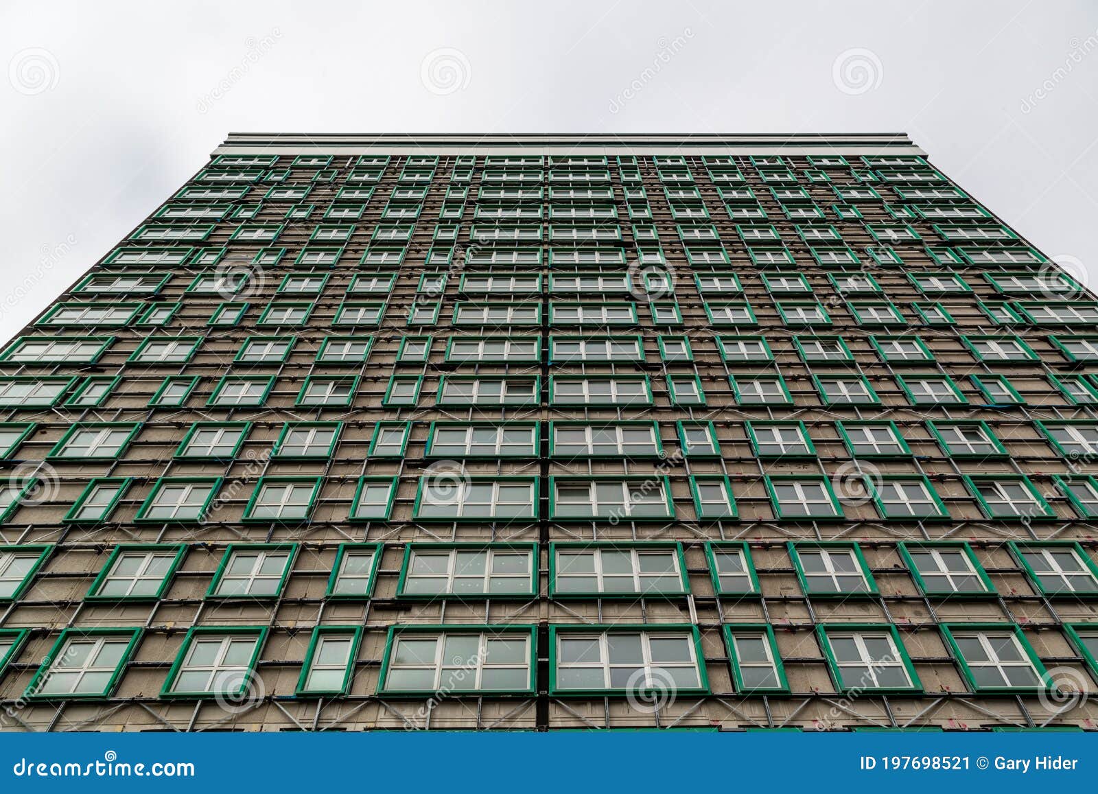 looking up at a tower block that has had its cladding removed due to being a fire hazard after the grenfell disaster, horatia