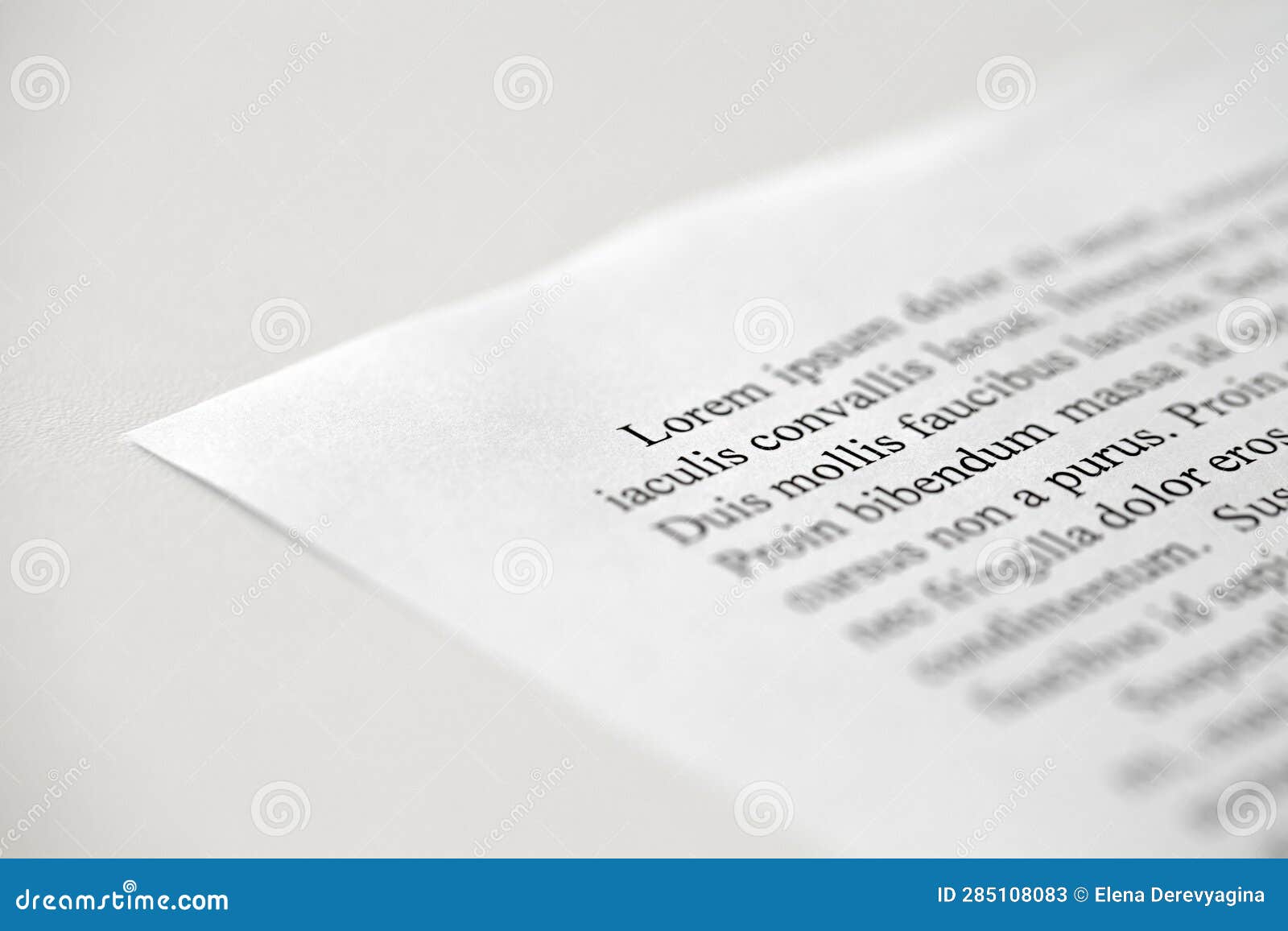 lorem ipsum dolor text on printed on paper in black and white, sample of document, side view, selective focus