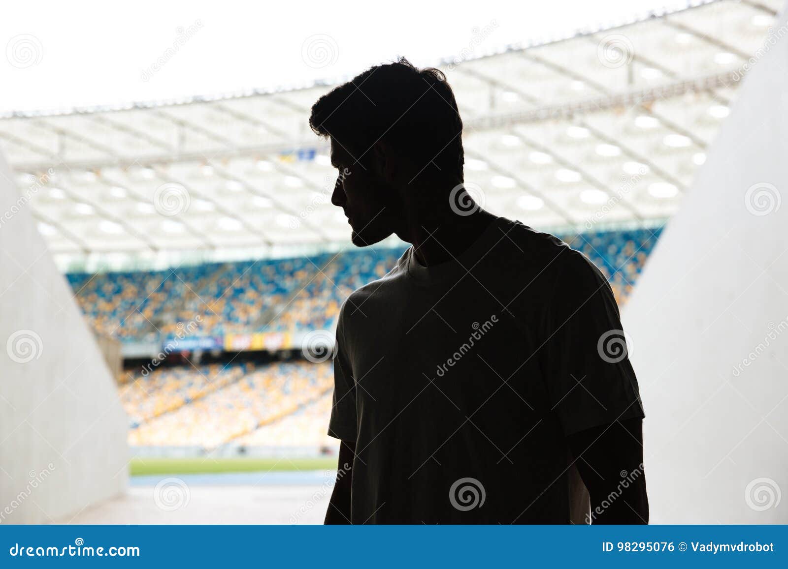 Los deportes jovenes sirven la situación en el estadio al aire libre. La imagen de deportes jovenes sirve la situación en el estadio al aire libre y mirando a un lado