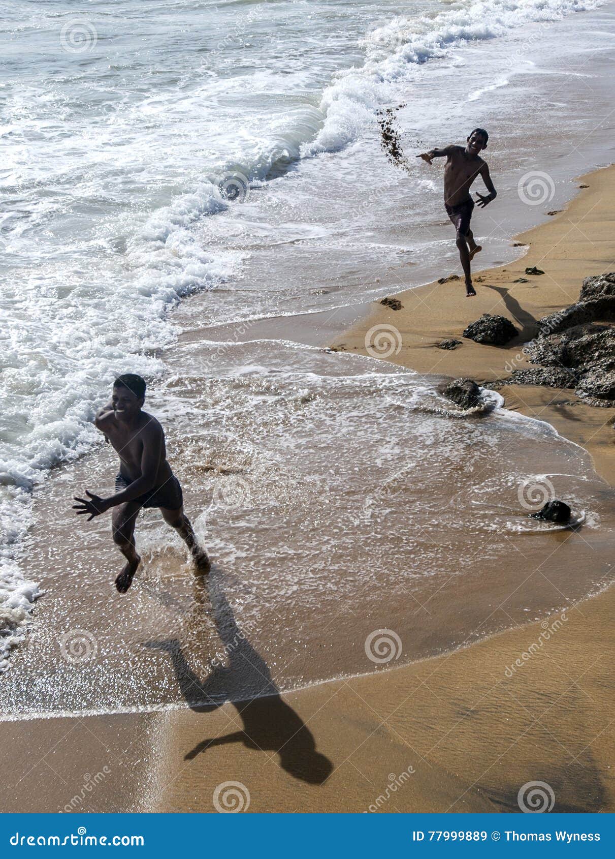 Los muchachos juegan en la playa arenosa adyacente a Galle hacen frente a verde en Colombo en Sri Lanka