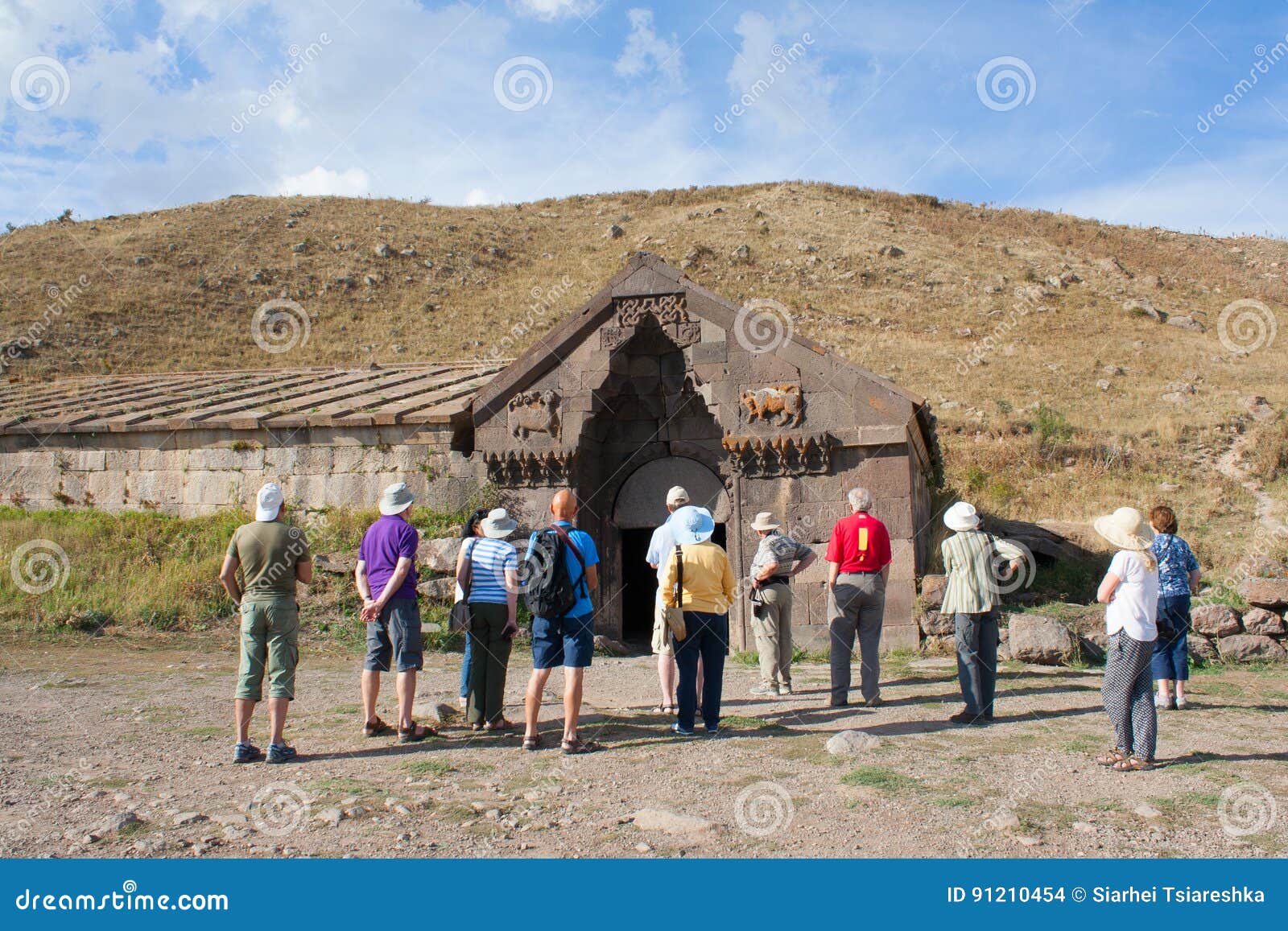 Los turistas cerca de la caravanseray del edificio en Vardenyats pasan armenia