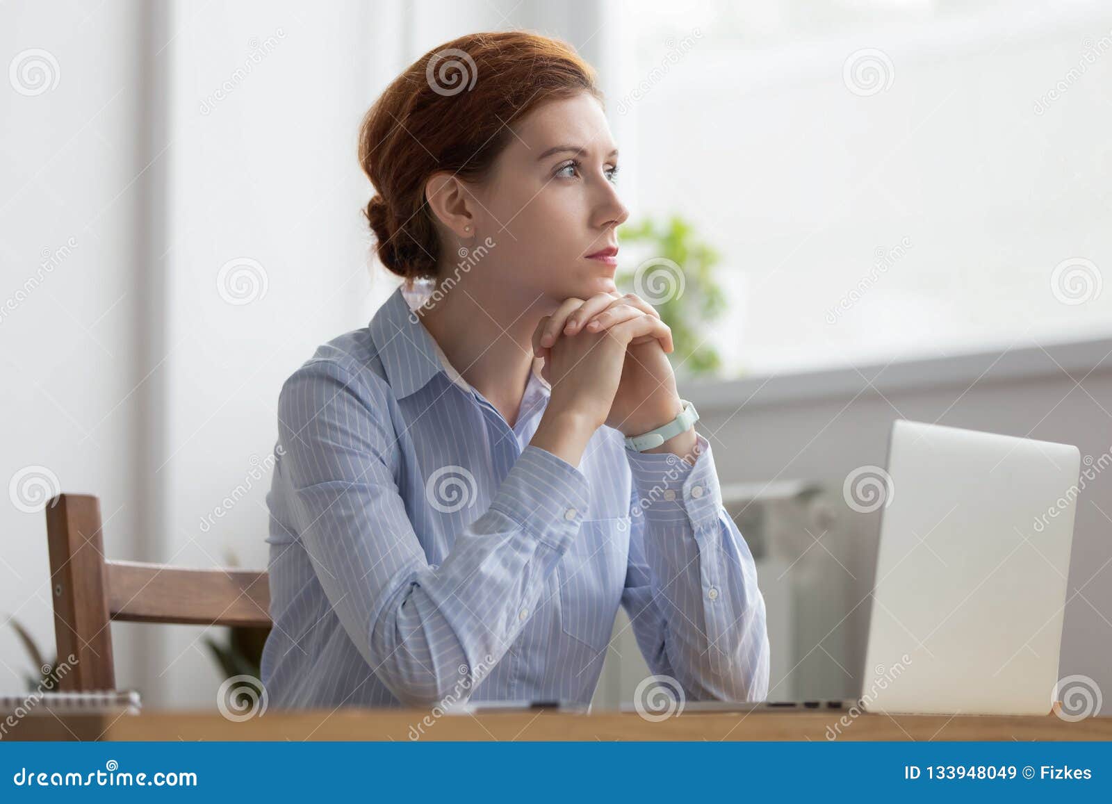 lost in thoughts woman sits at workplace desk in office