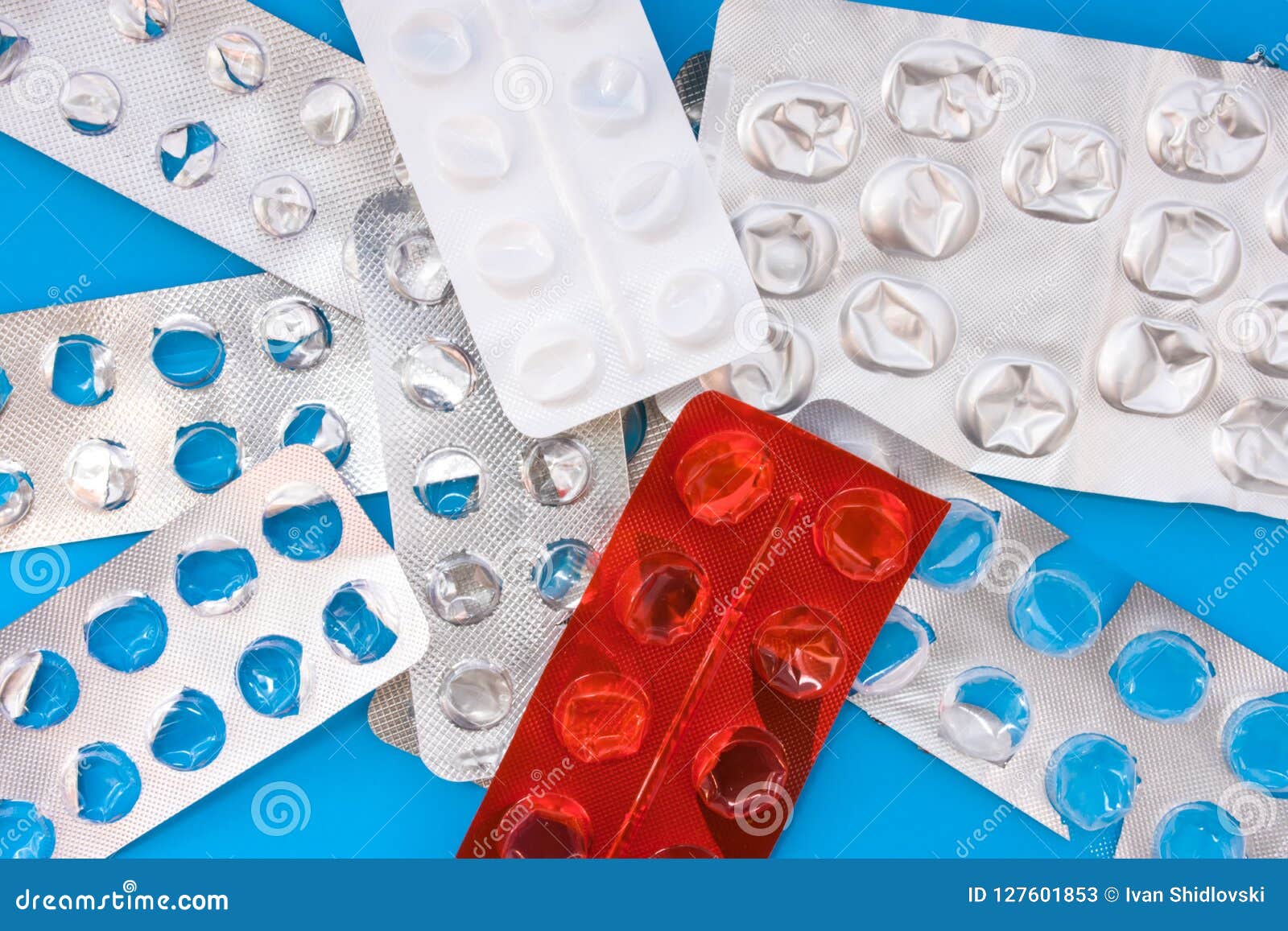 a lot of empty plastic blister packaging of pharmaceutical tablets and pills on blue background. concept of end of treatment, the