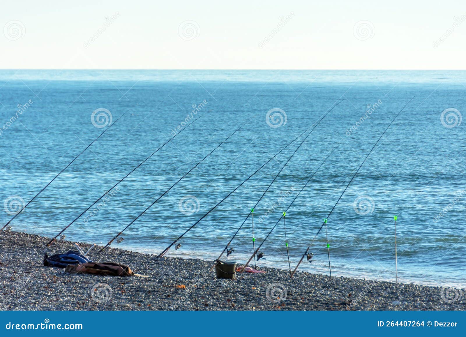 Lot of Fishing Rods Lined Up on the Seashore. Large-scale Fishing