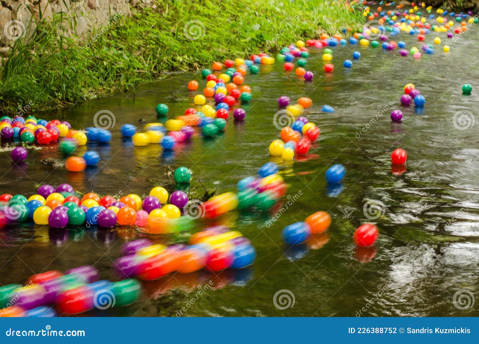Lots of Colorful Plastic Balls with Numbers in the River Stock Photo