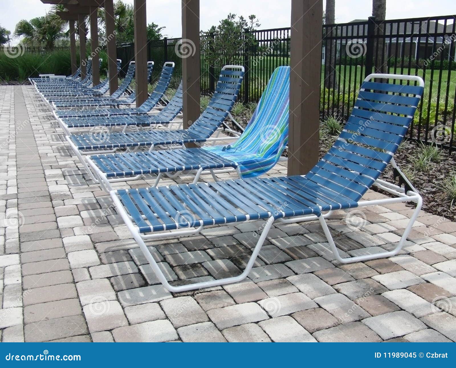 Lounge chairs at pool stock image. Image of sunbathing - 11989045