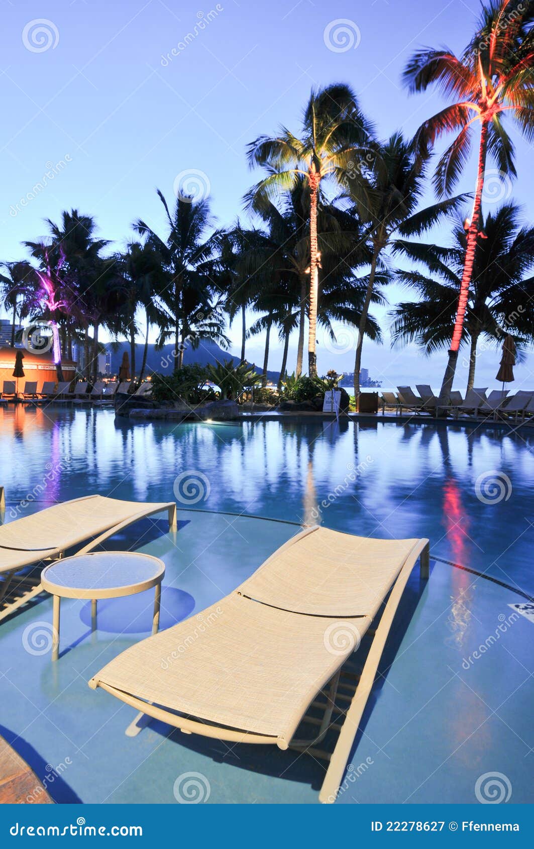 Lounge Chairs By Swimming Pool At Night Time Stock Image
